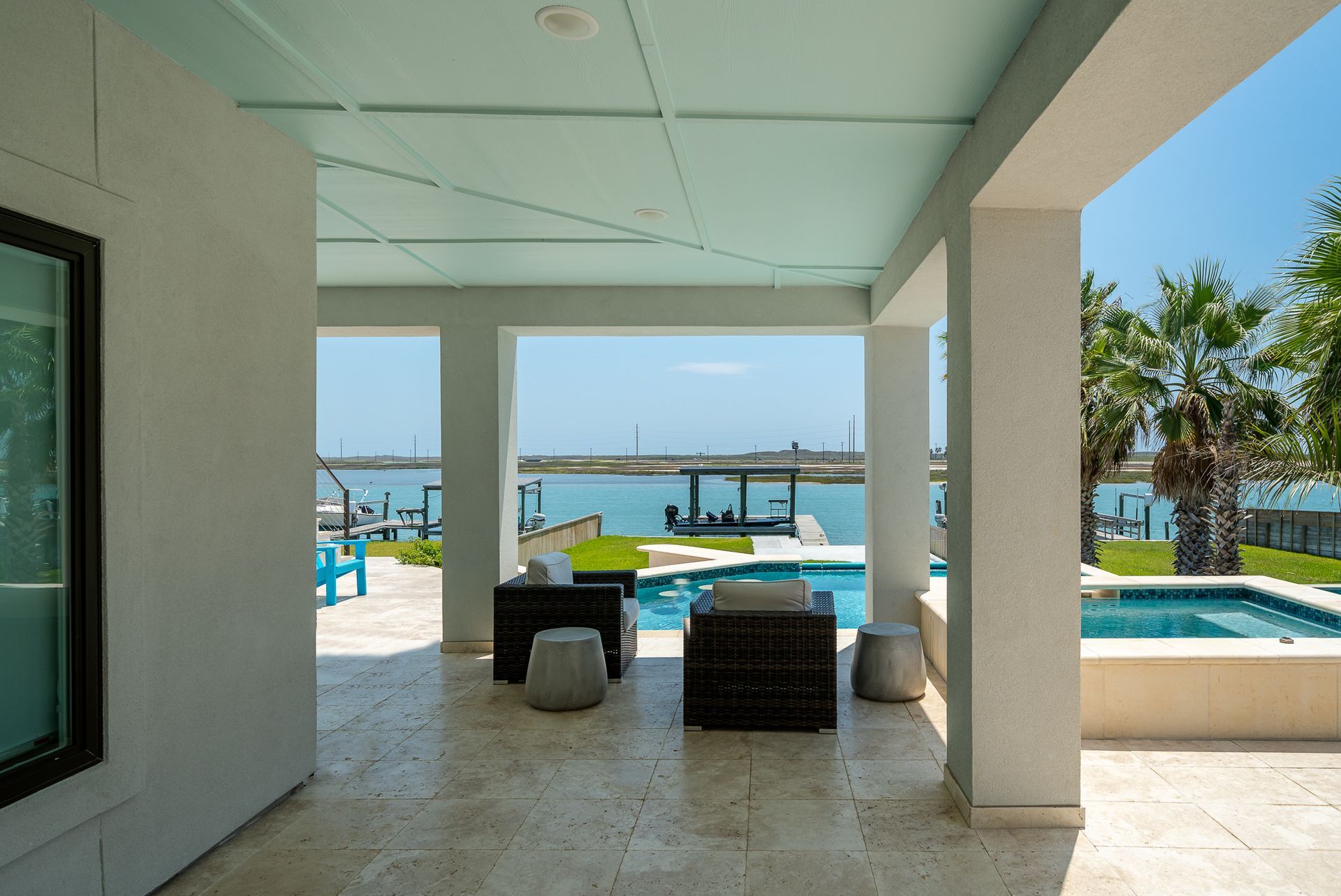 A patio with a view of the ocean and a swimming pool
