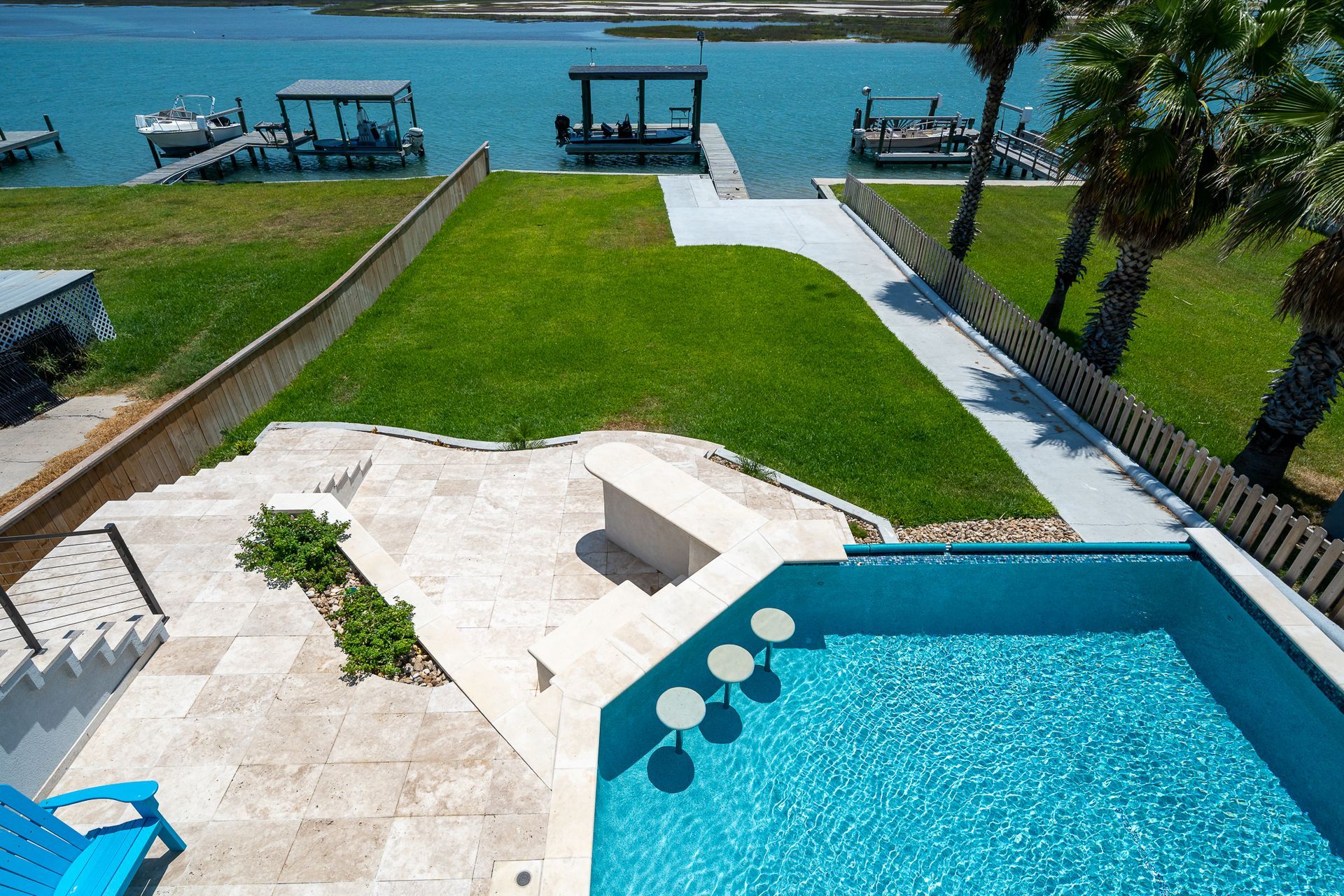 An aerial view of a swimming pool with a dock in the background