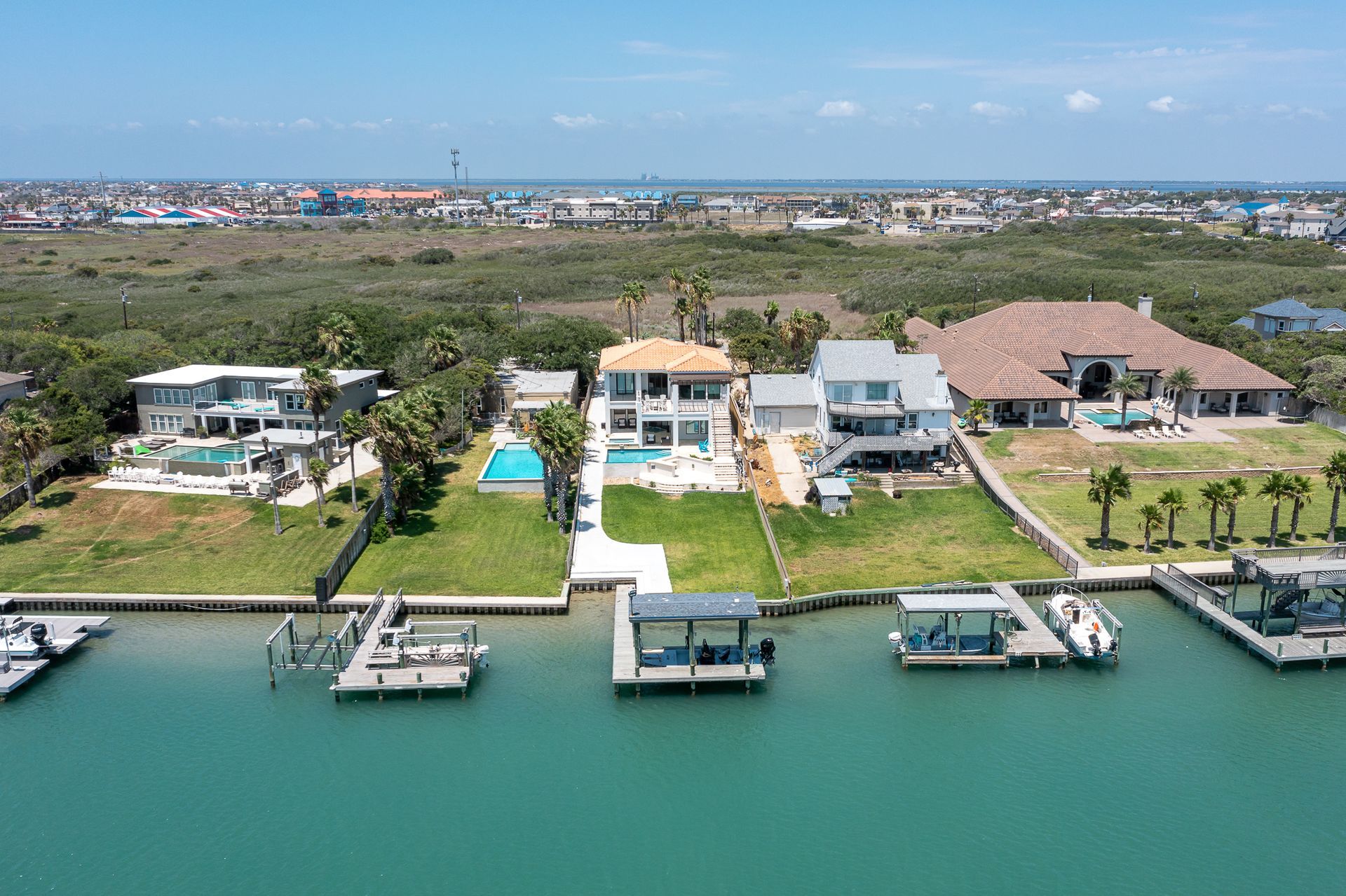 An aerial view of a residential area with lots of houses and boats docked in the water.