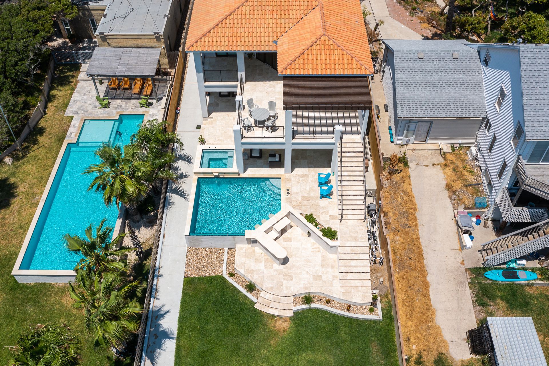 An aerial view of a large house with a swimming pool in the backyard.
