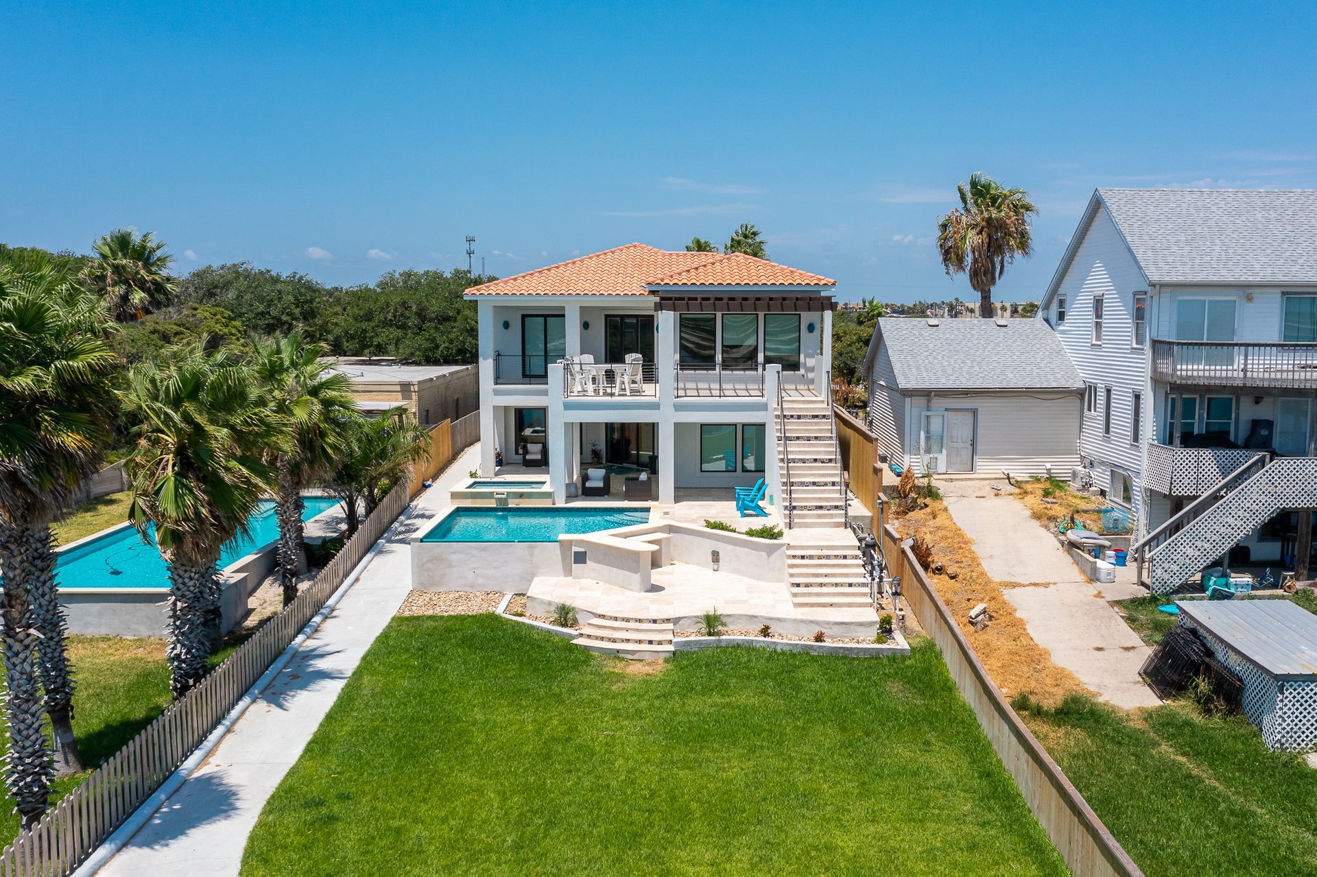 An aerial view of a large house with a swimming pool in the backyard.