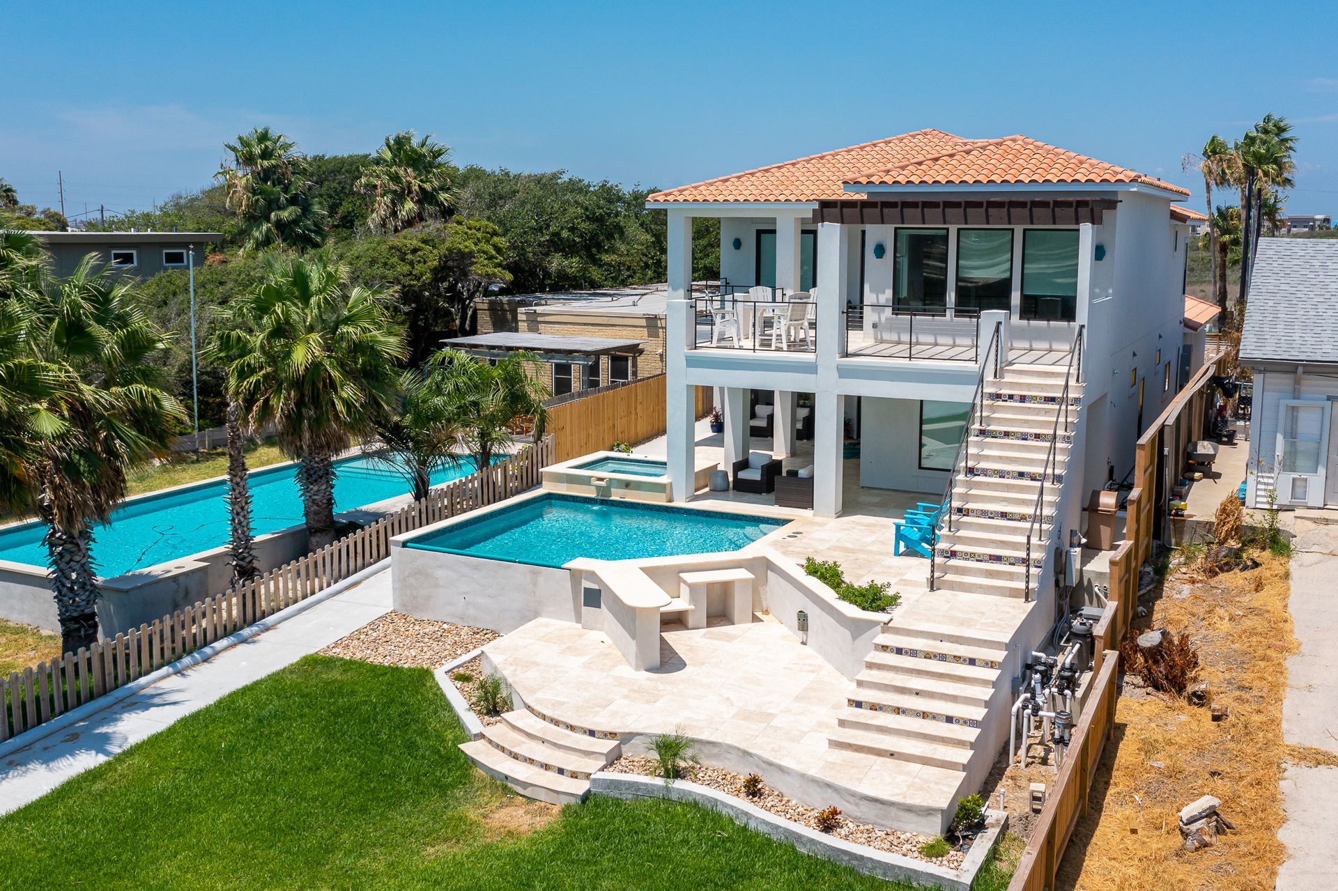 An aerial view of a large house with a swimming pool in the backyard.
