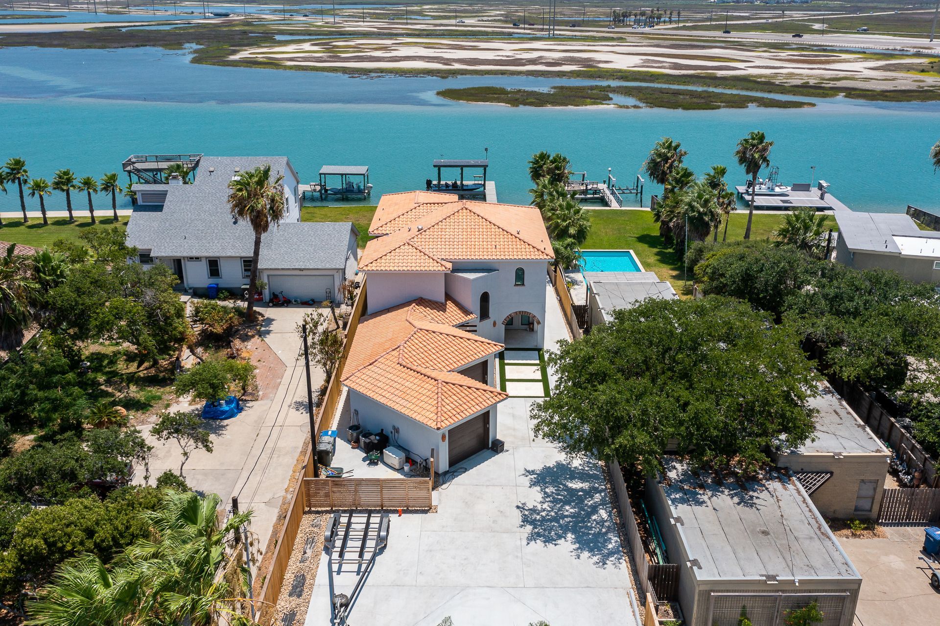 An aerial view of a house next to a body of water