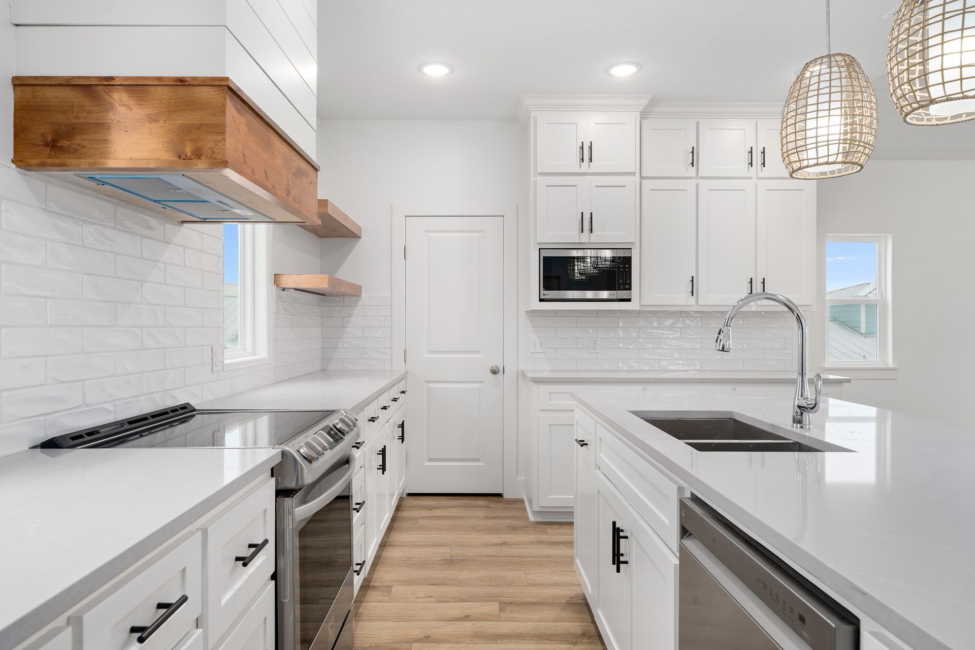 A kitchen with white cabinets , stainless steel appliances , a sink , and a stove.