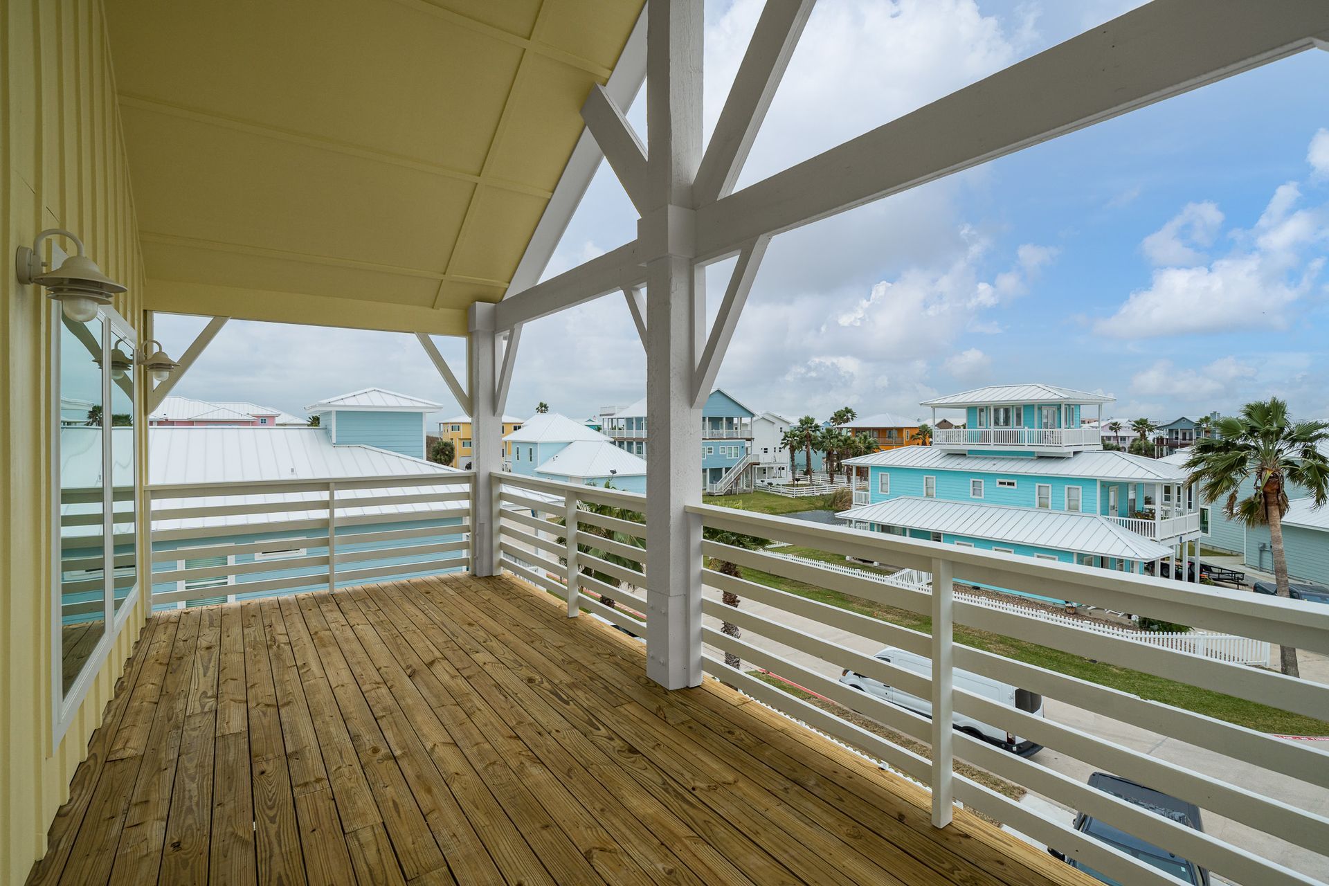 An empty deck with a white railing and a view of a city