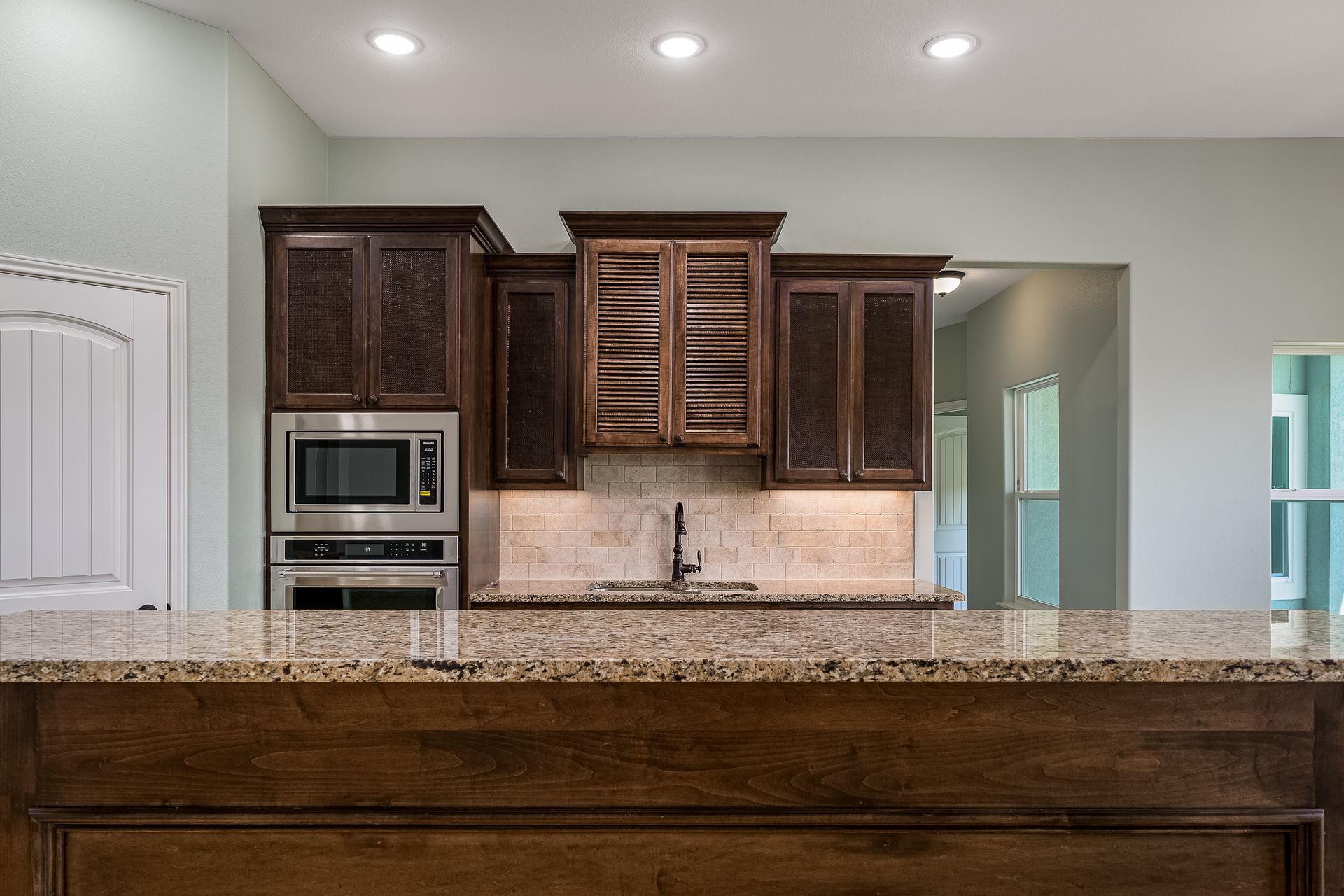 A kitchen with stainless steel appliances and granite counter tops.