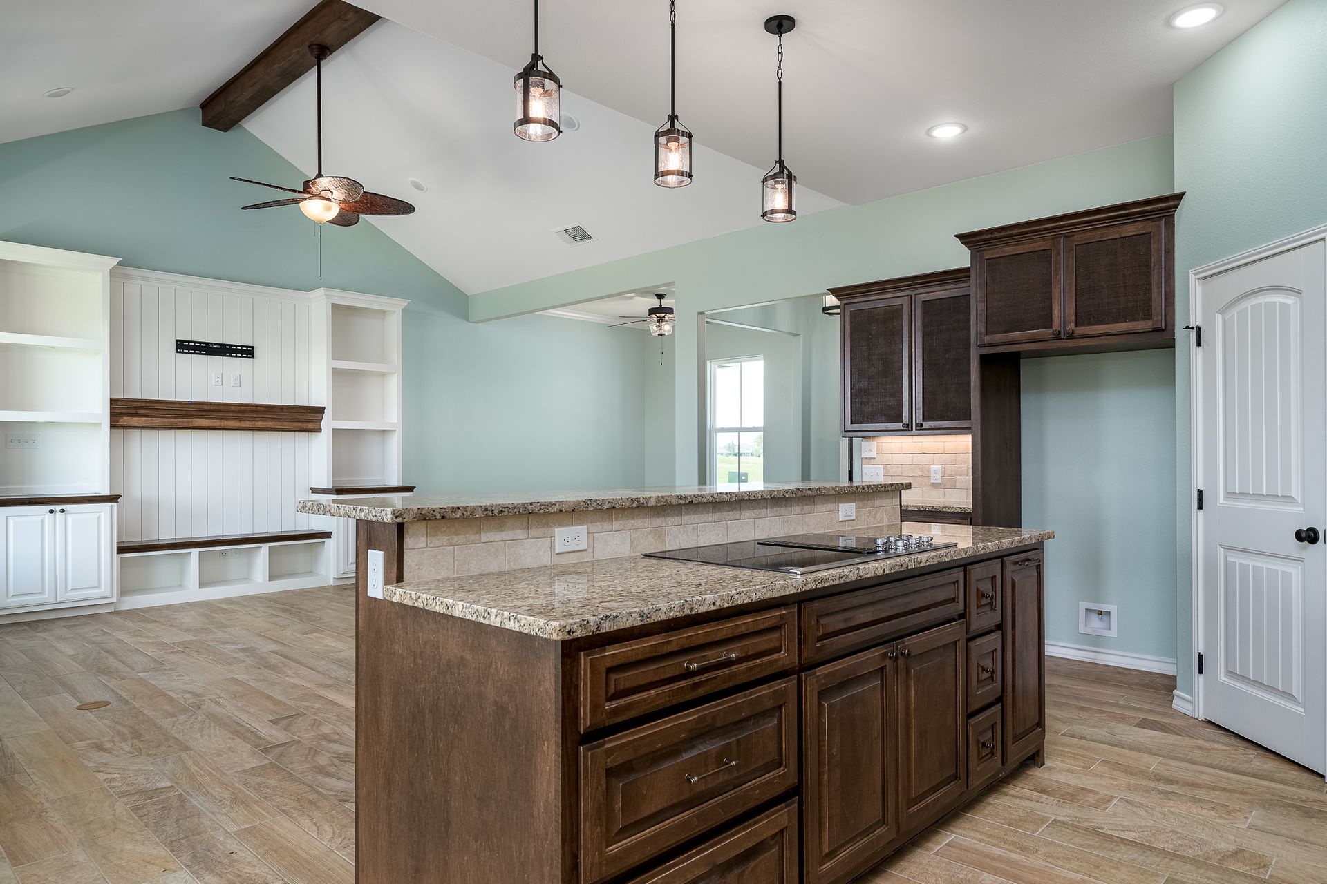 A kitchen with a large island and granite counter tops