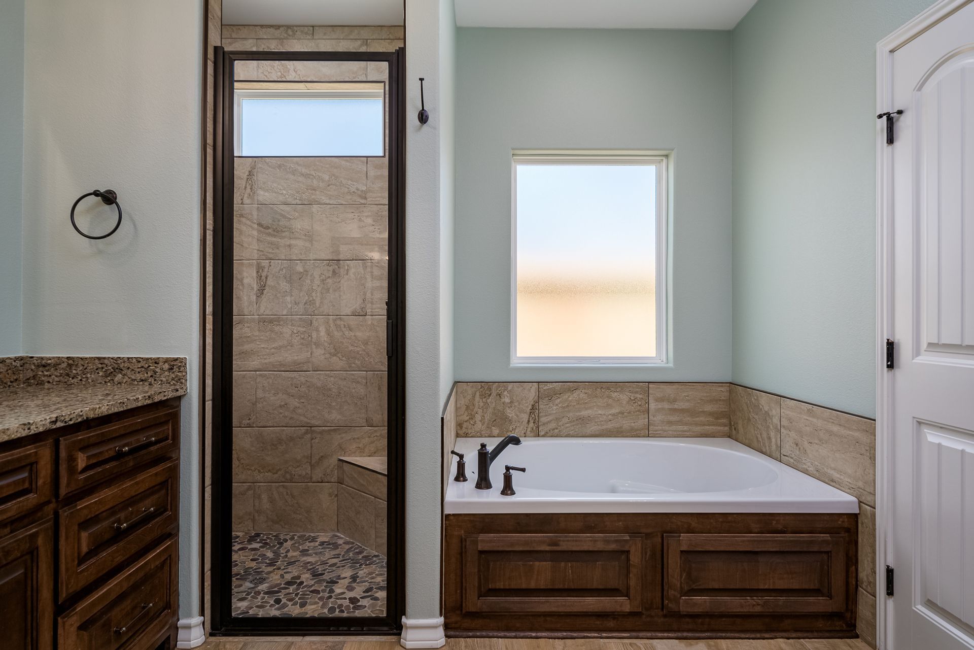A bathroom with a tub and a walk in shower.