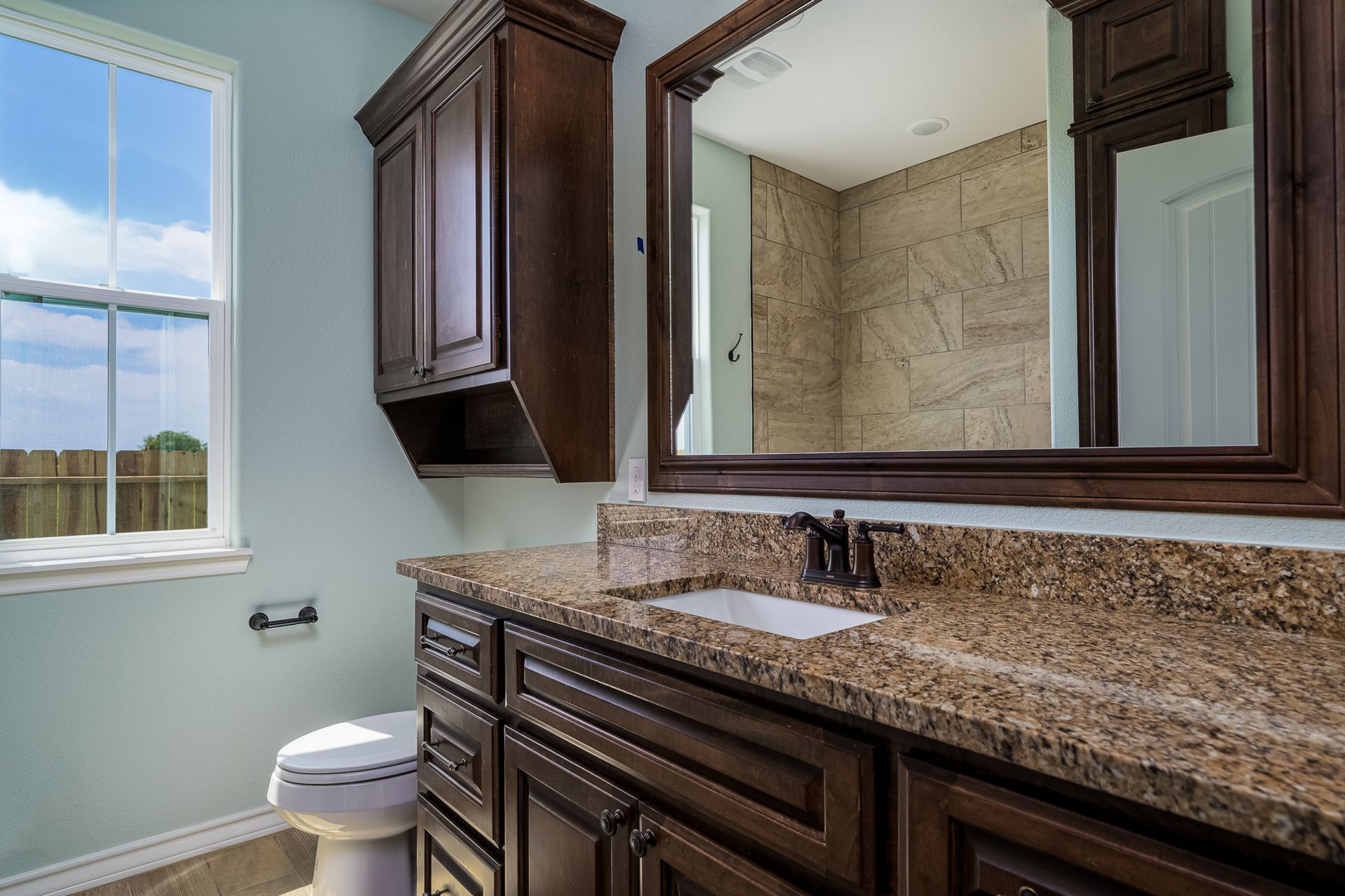 A bathroom with a sink , toilet and mirror
