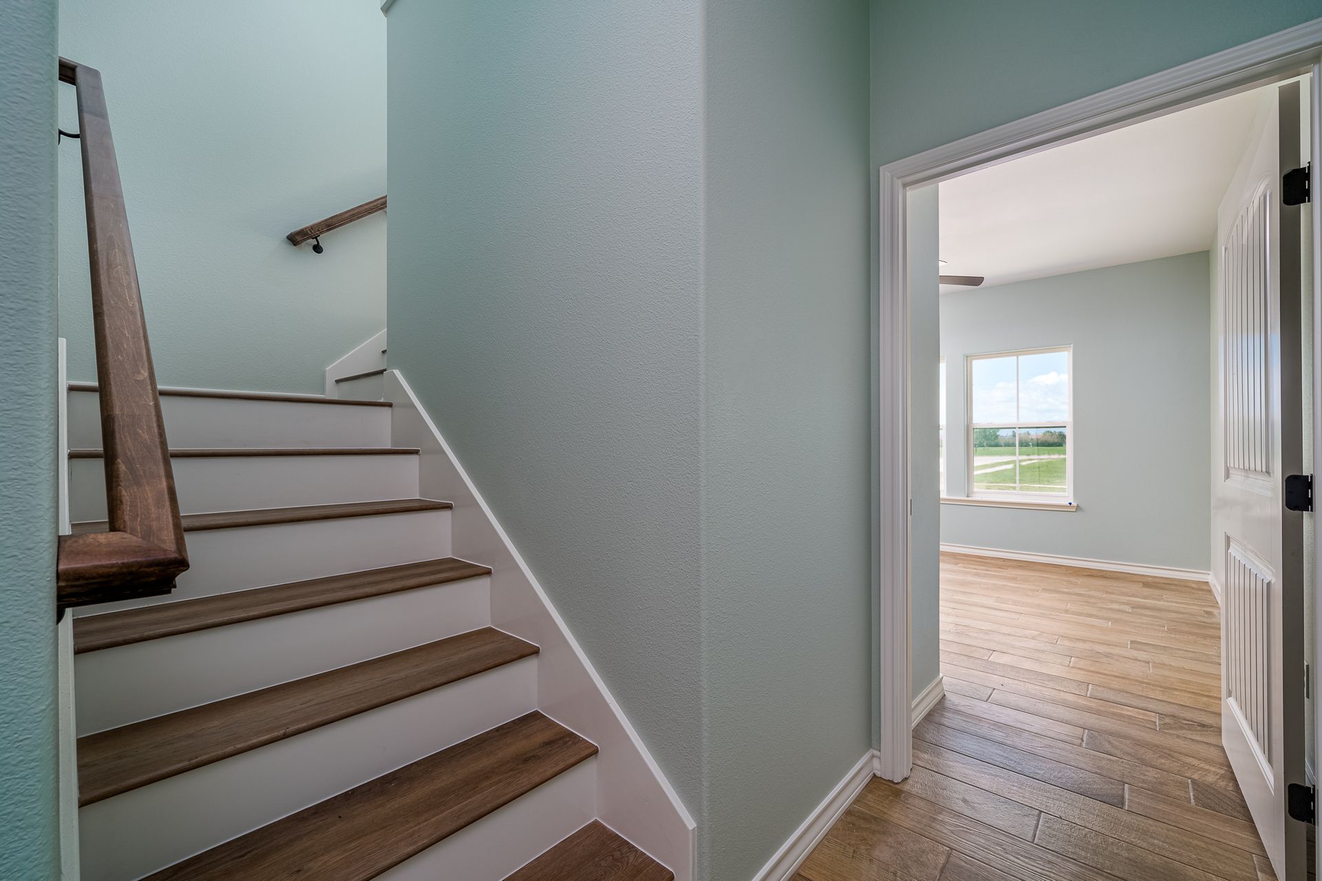 A hallway with stairs leading up to the second floor of a house