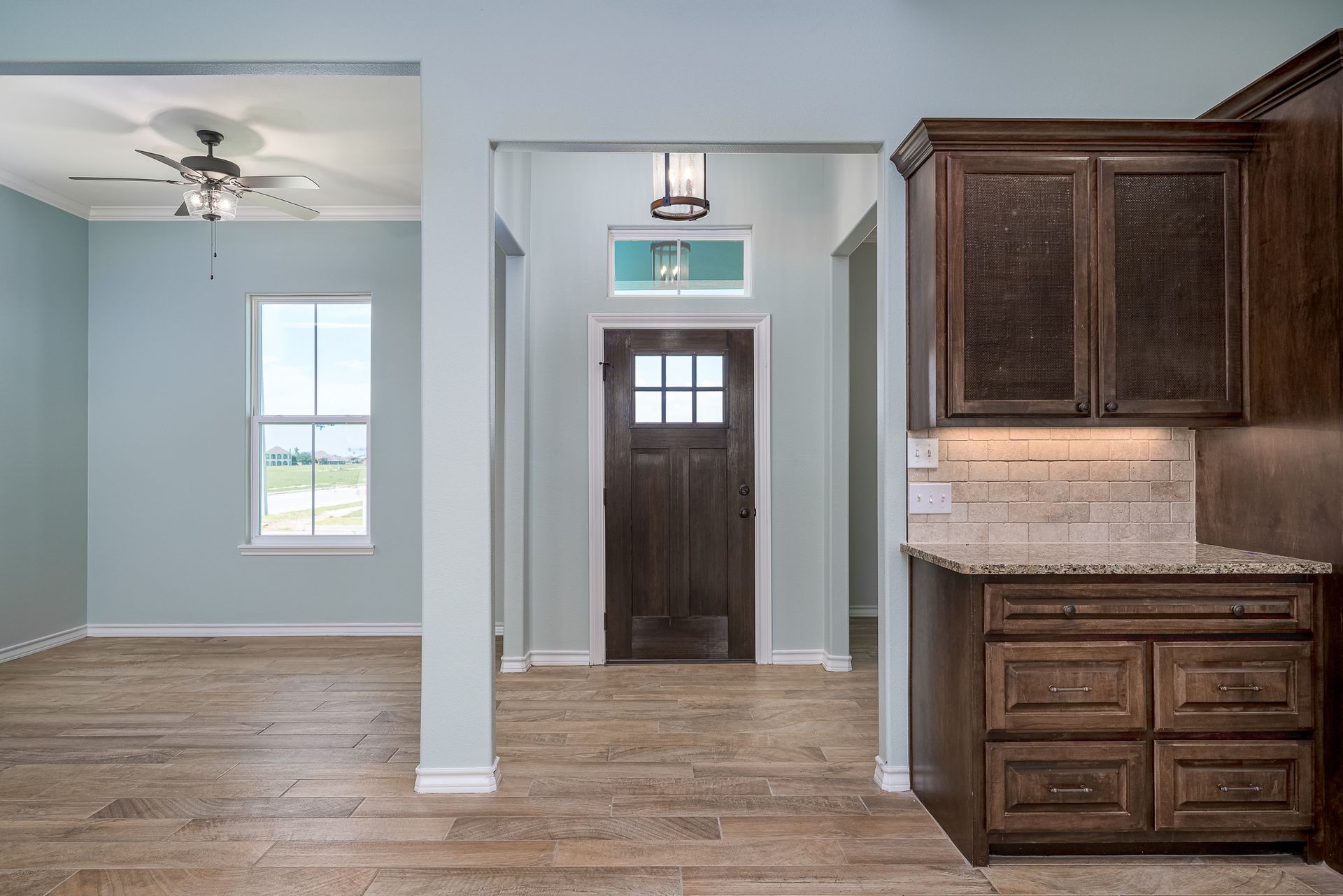 A kitchen with wooden cabinets and a ceiling fan.