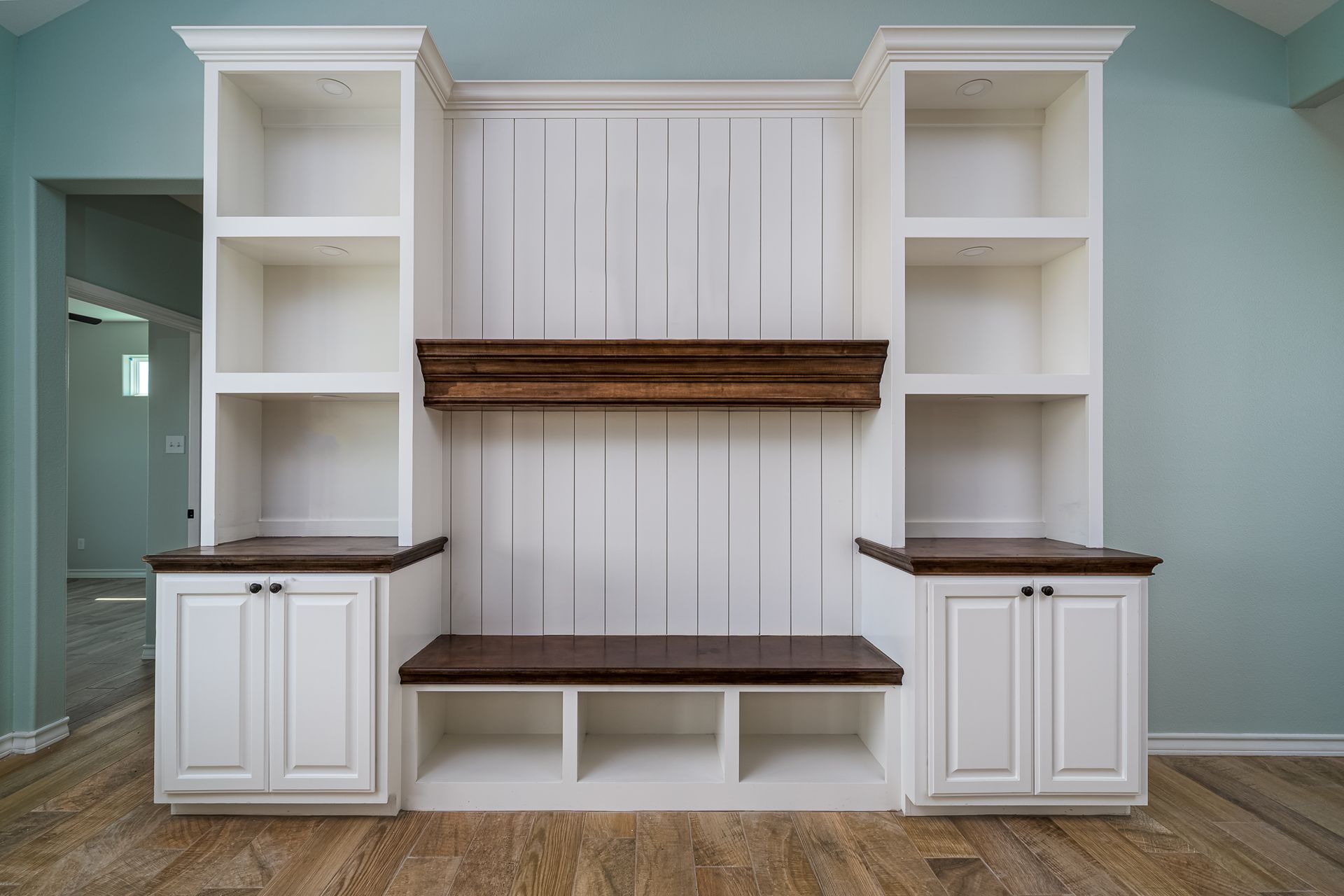 A living room with white cabinets , shelves , and a fireplace.
