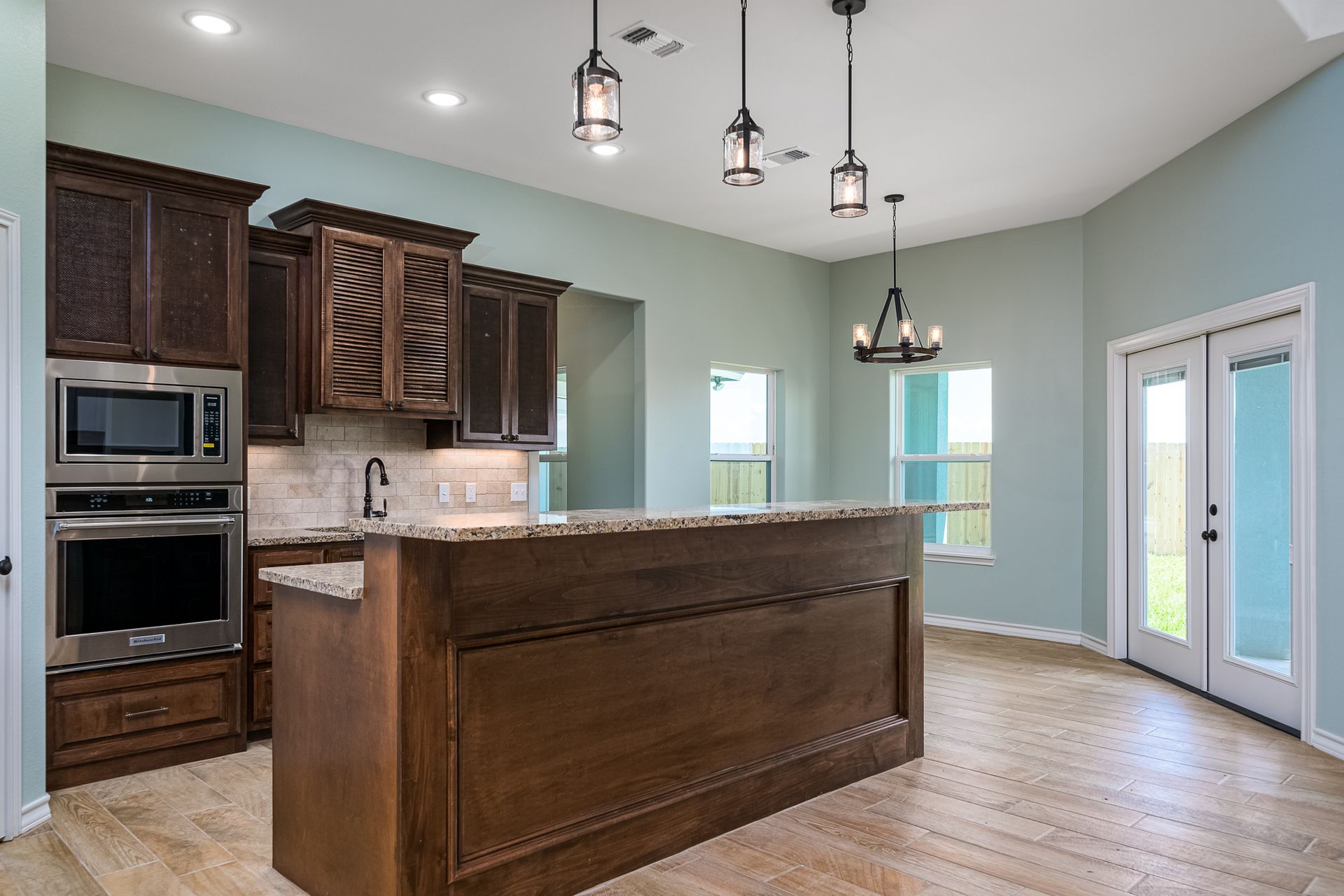 A kitchen with a large island and stainless steel appliances