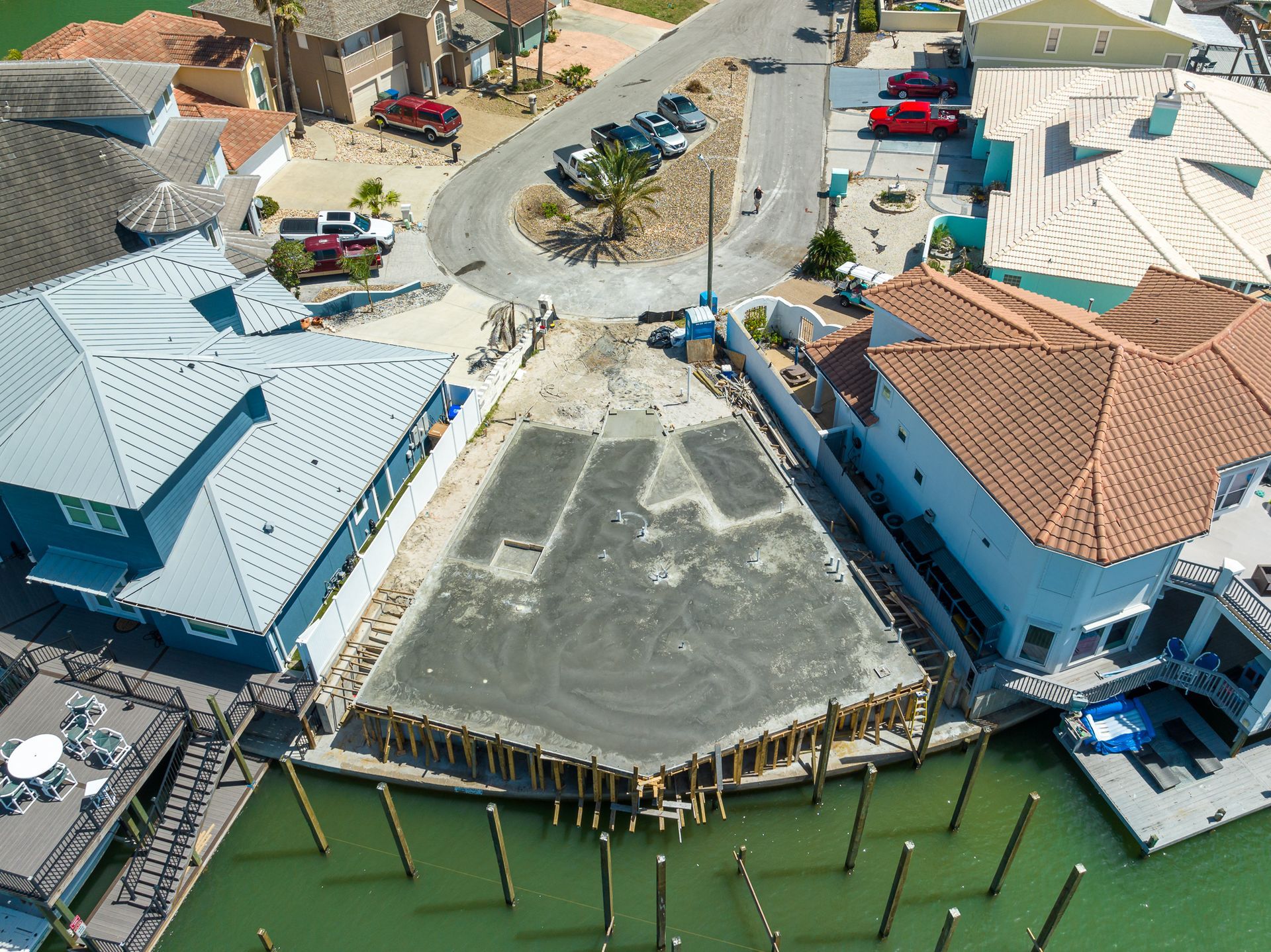 An aerial view of a building under construction next to a body of water.