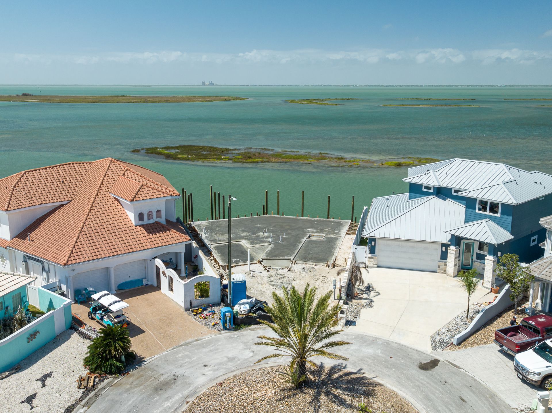 An aerial view of a house next to a body of water