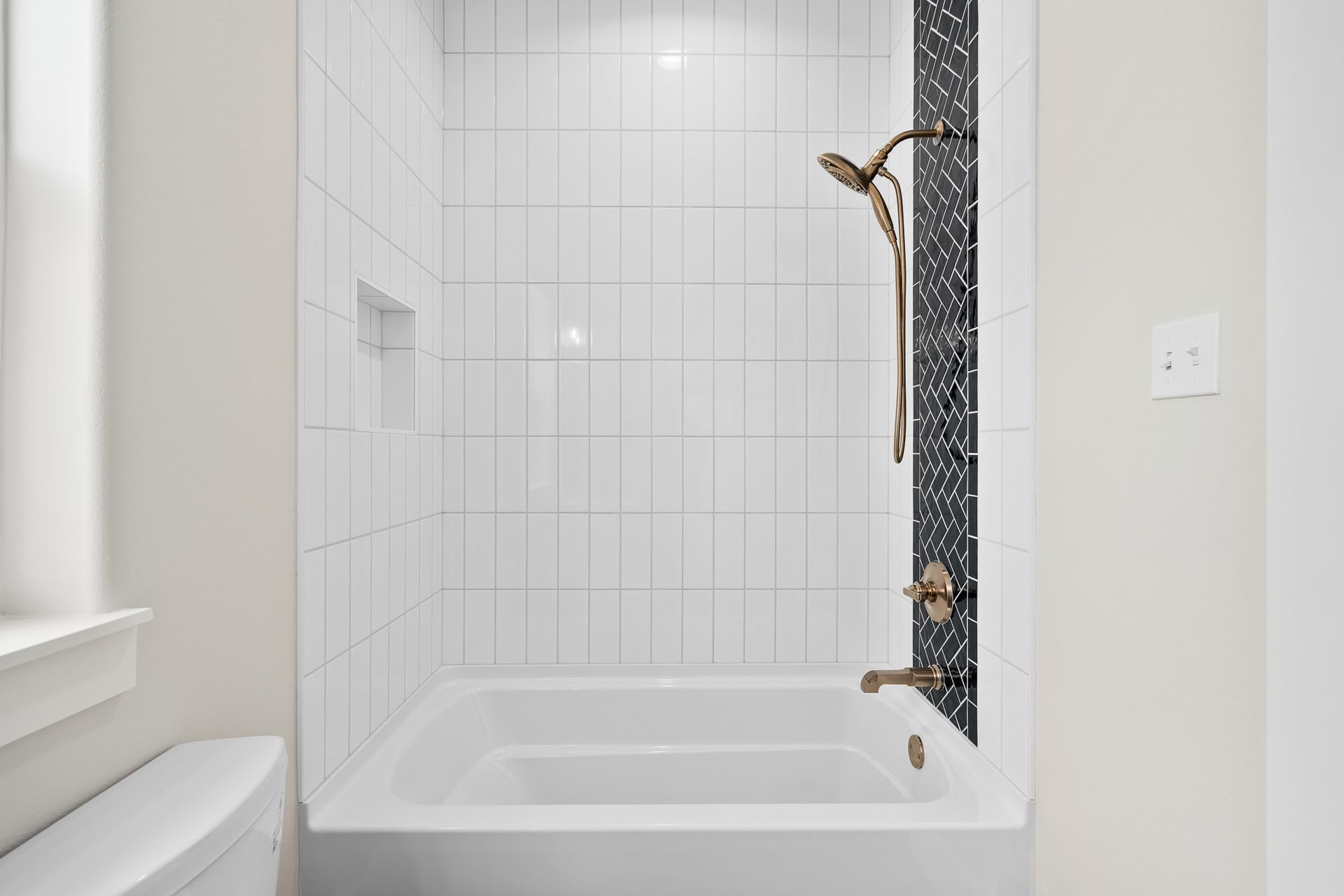 A bathroom with a bathtub , toilet and shower.