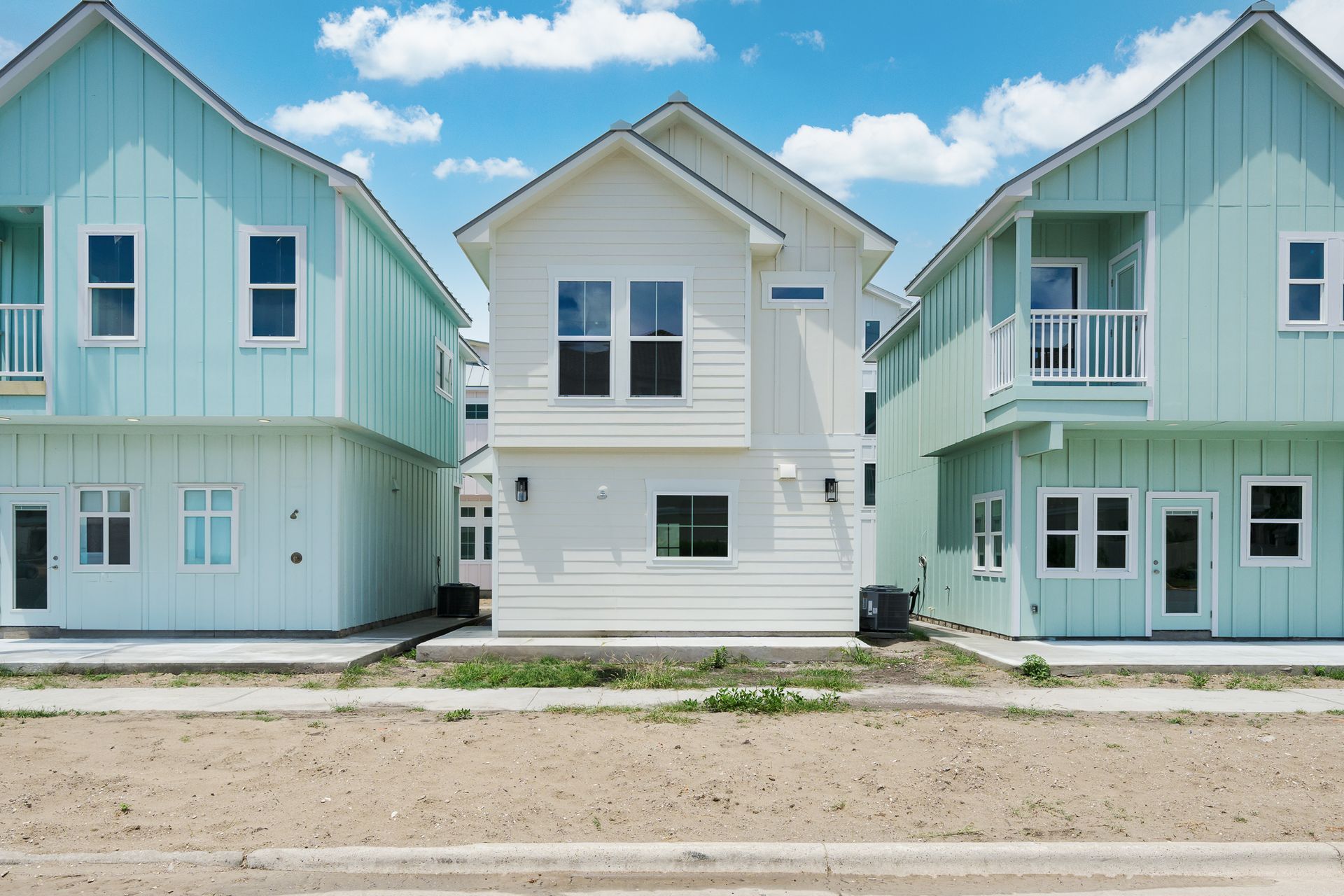 A row of blue and white houses with a blue sky in the background