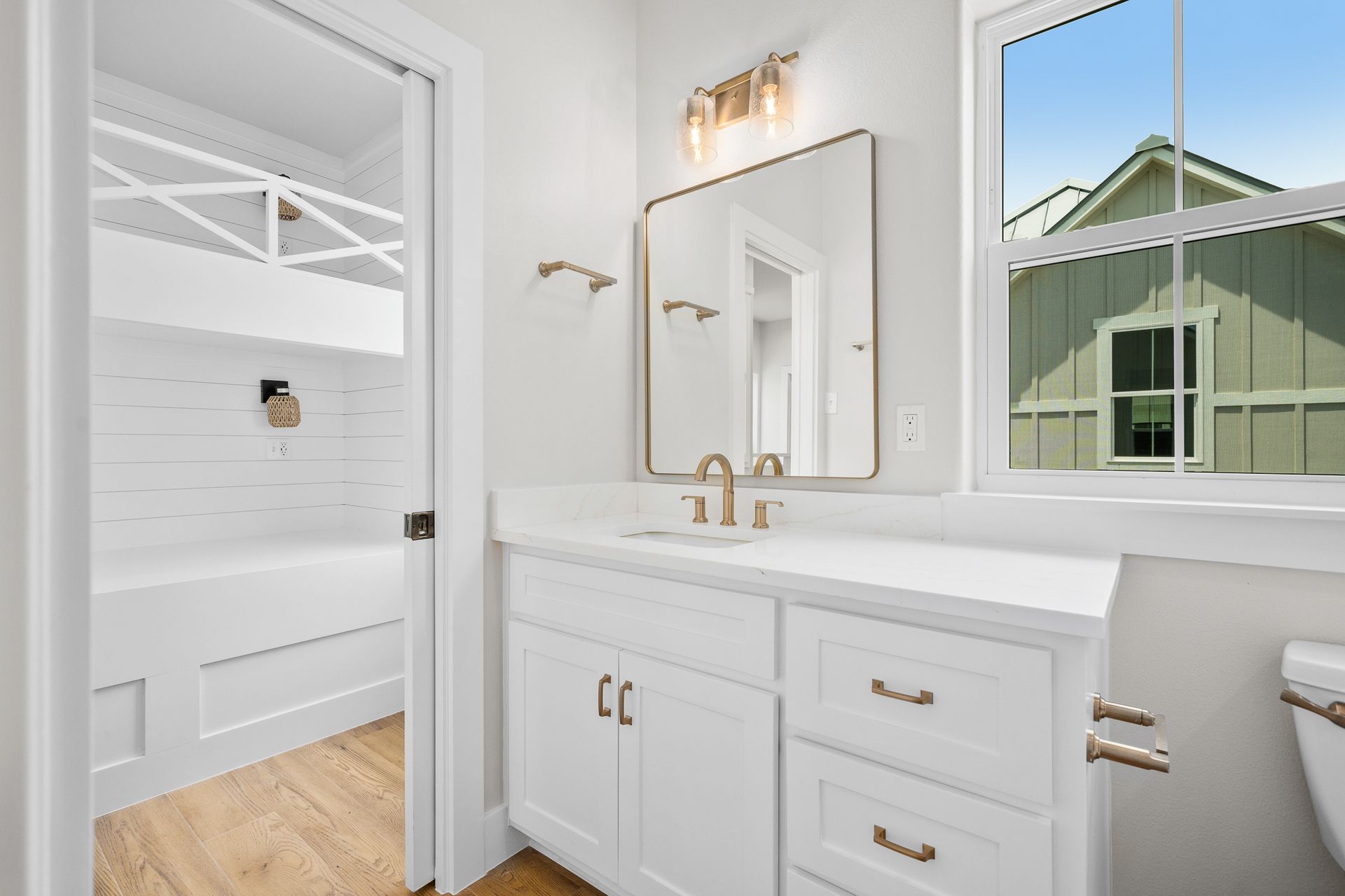 A bathroom with a sink , mirror , and bunk beds.
