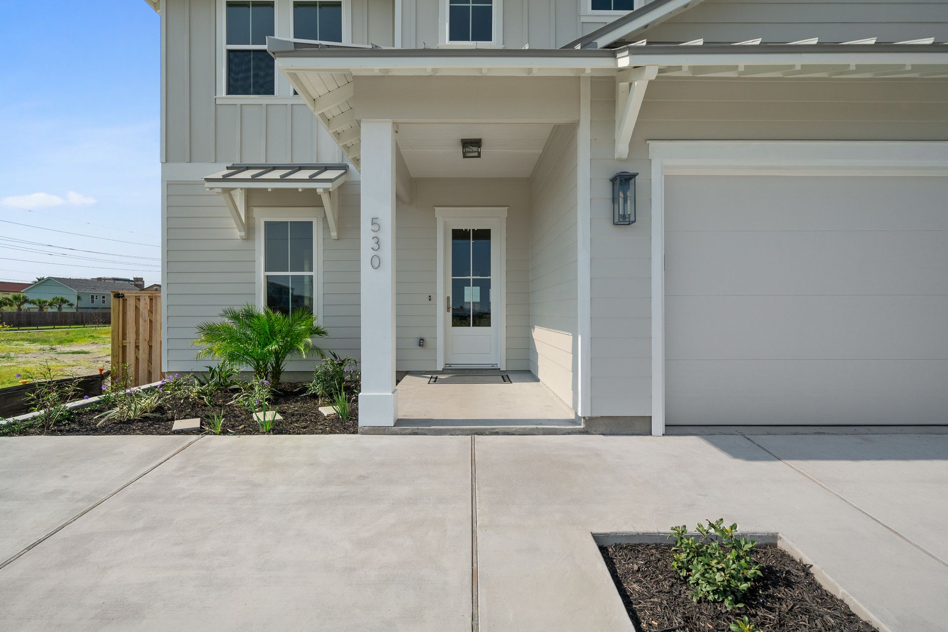 A white house with a white door and a white garage door.