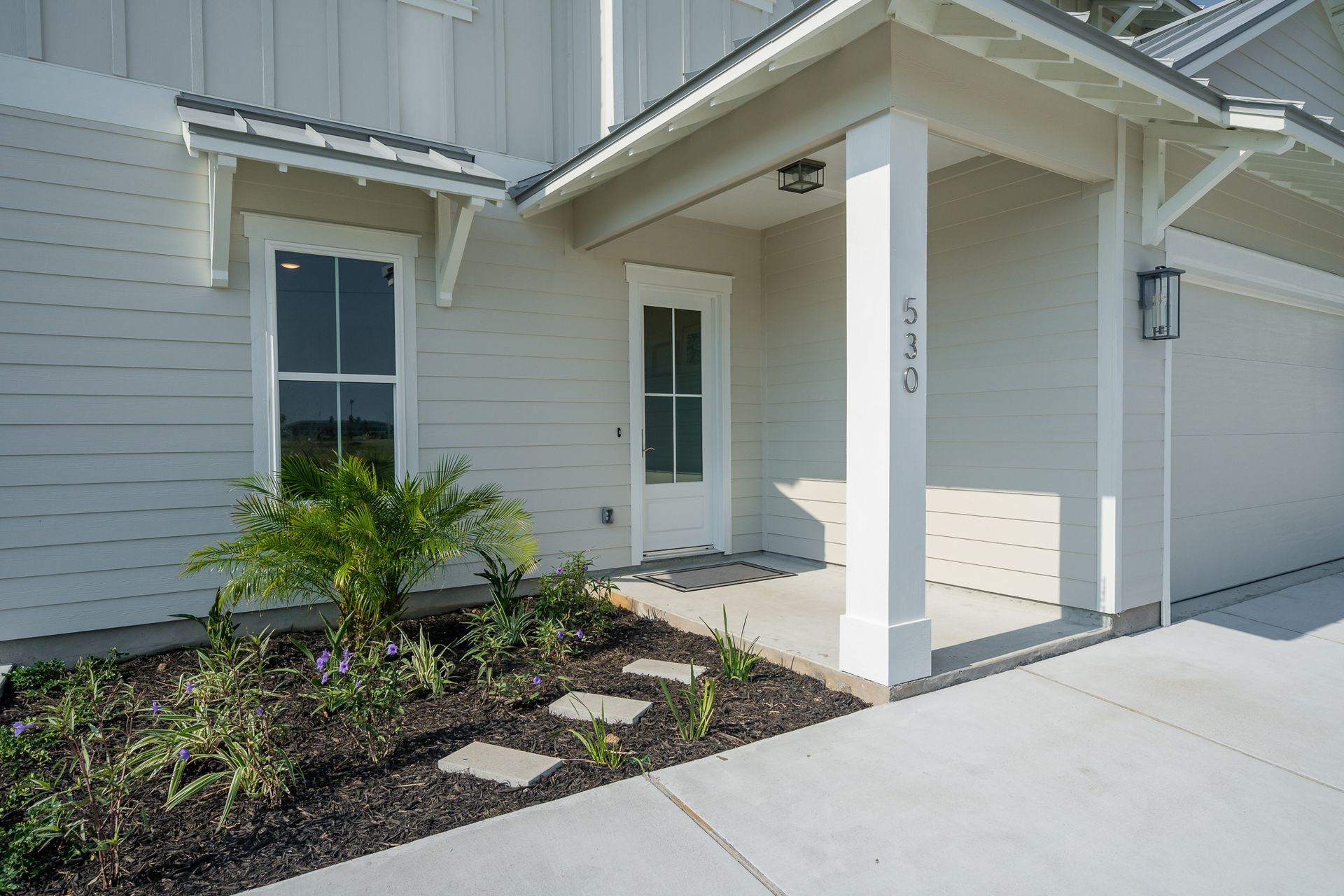 A white house with a porch and a white door.