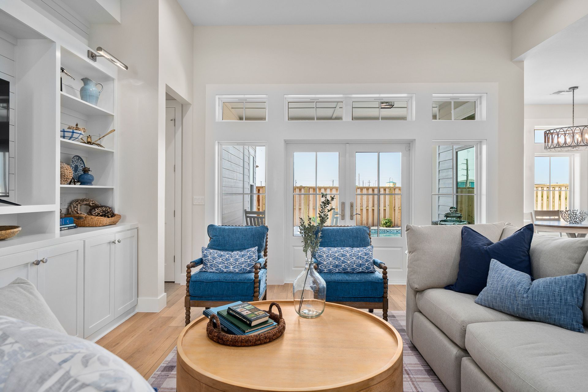 A living room with a couch , chairs , and a round coffee table.