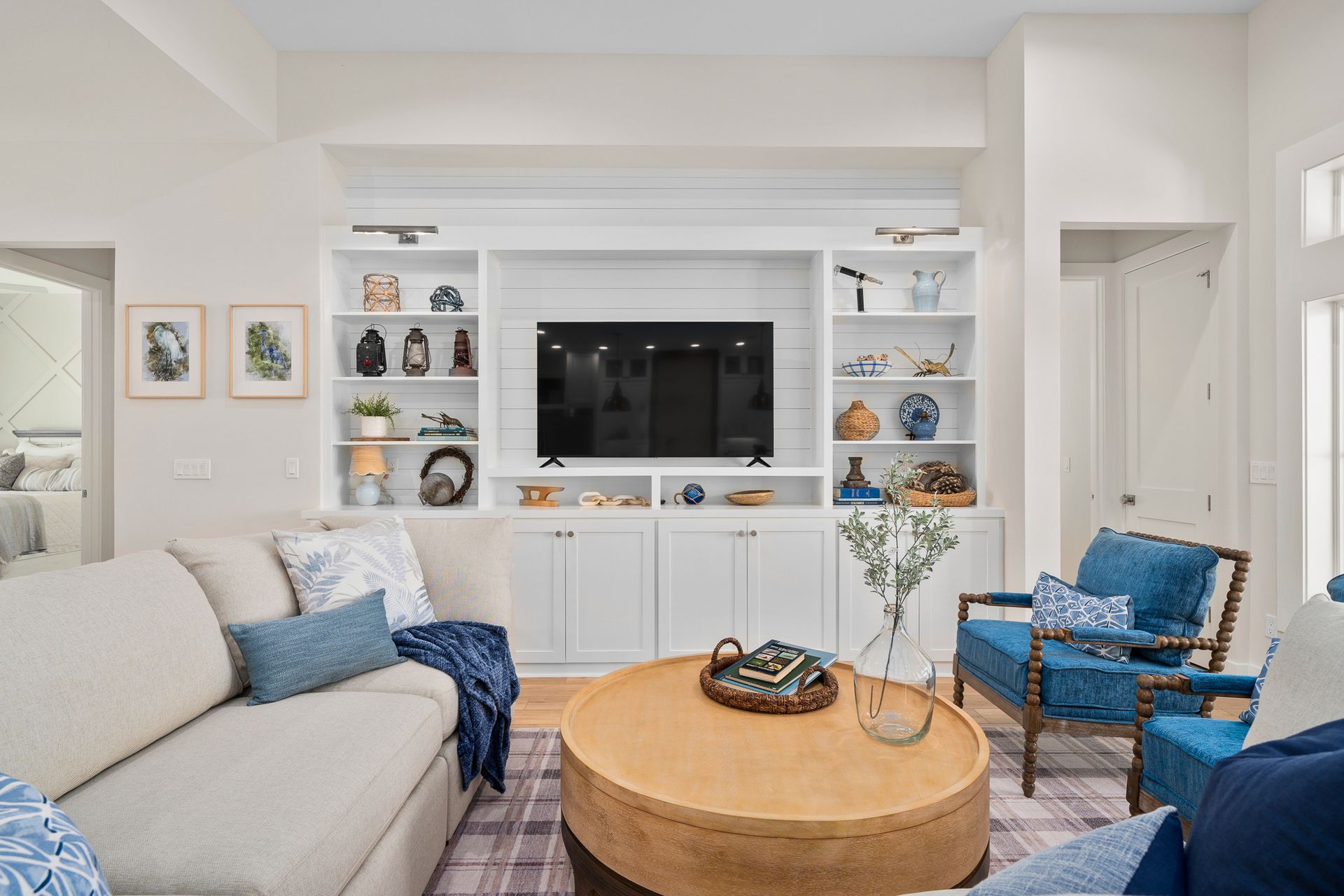 A living room with a couch , chairs , coffee table and television.