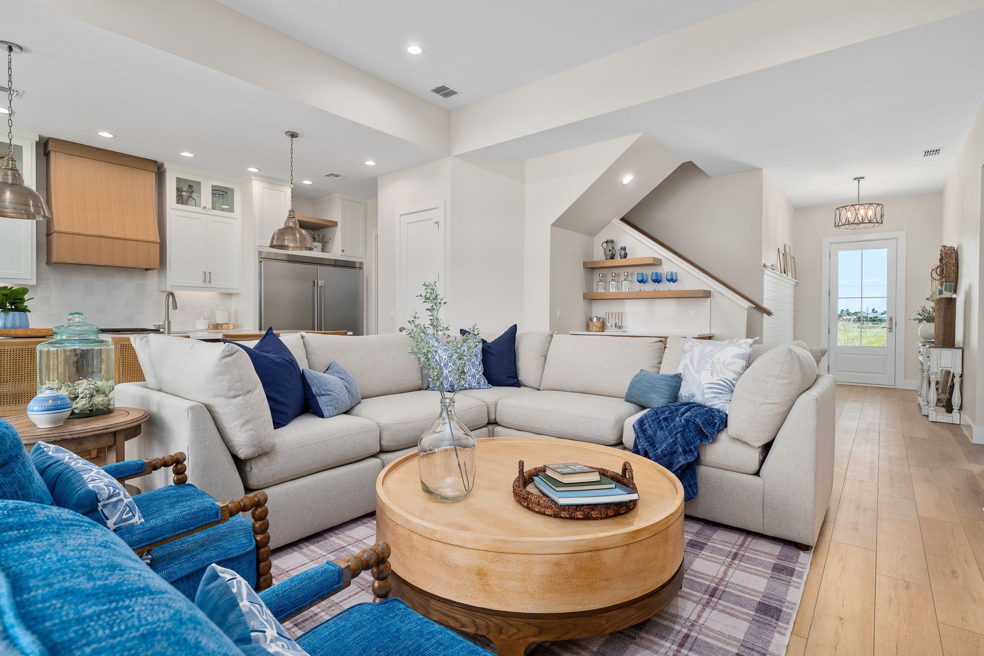 A living room with a large sectional couch and a round coffee table.