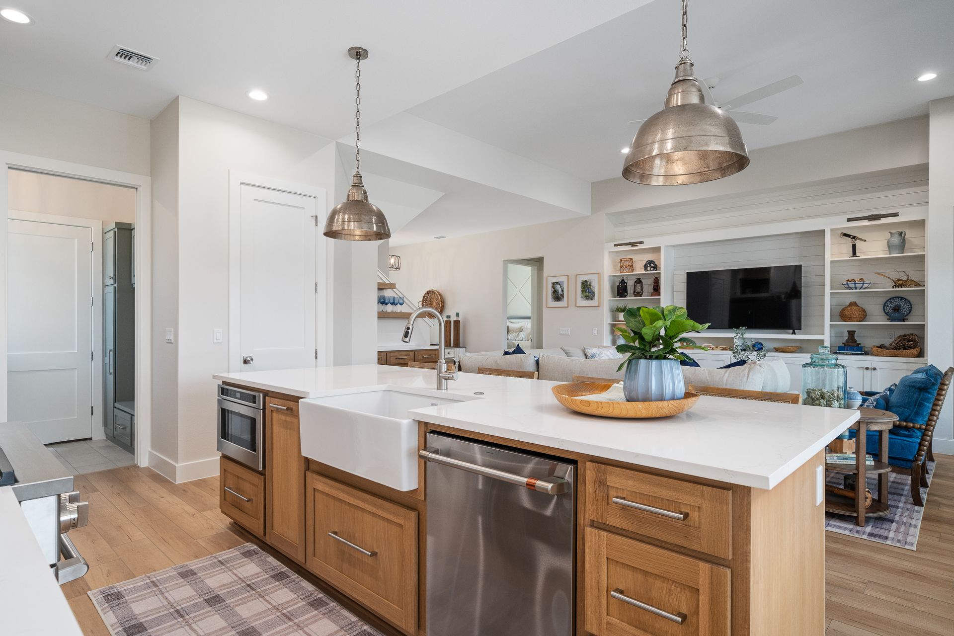A kitchen with a large island , stainless steel appliances , wooden cabinets and a sink.