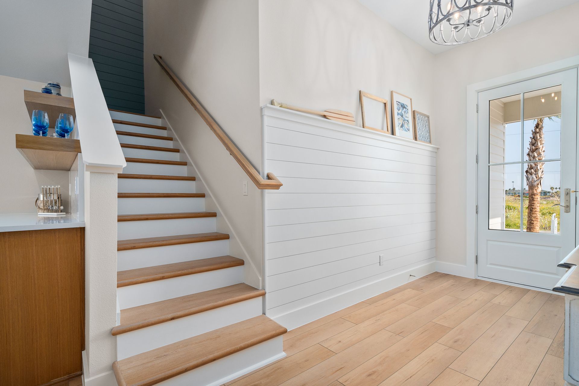 A hallway with stairs leading up to the second floor of a house.