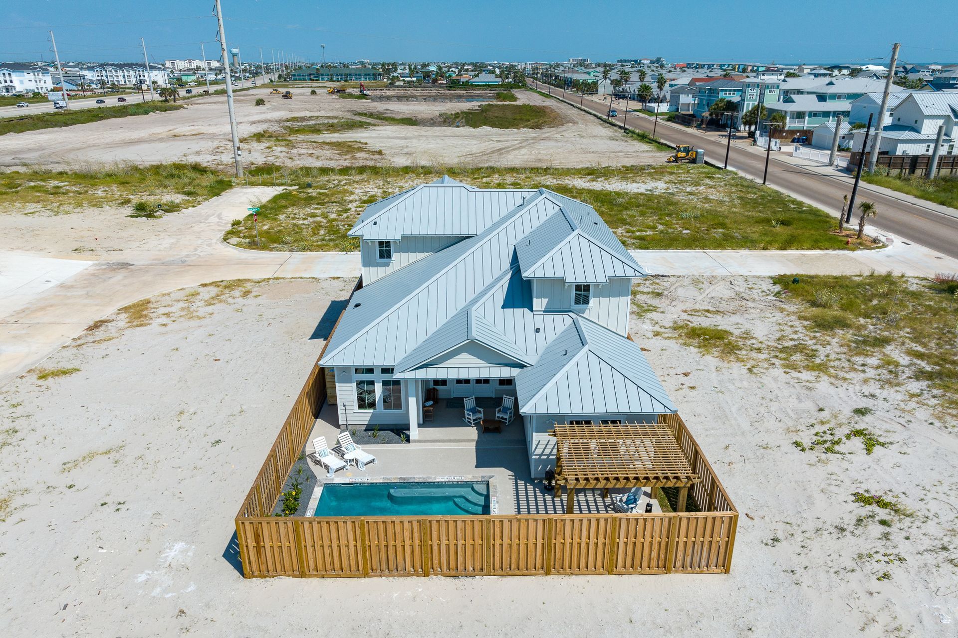 An aerial view of a house with a pool on the beach.