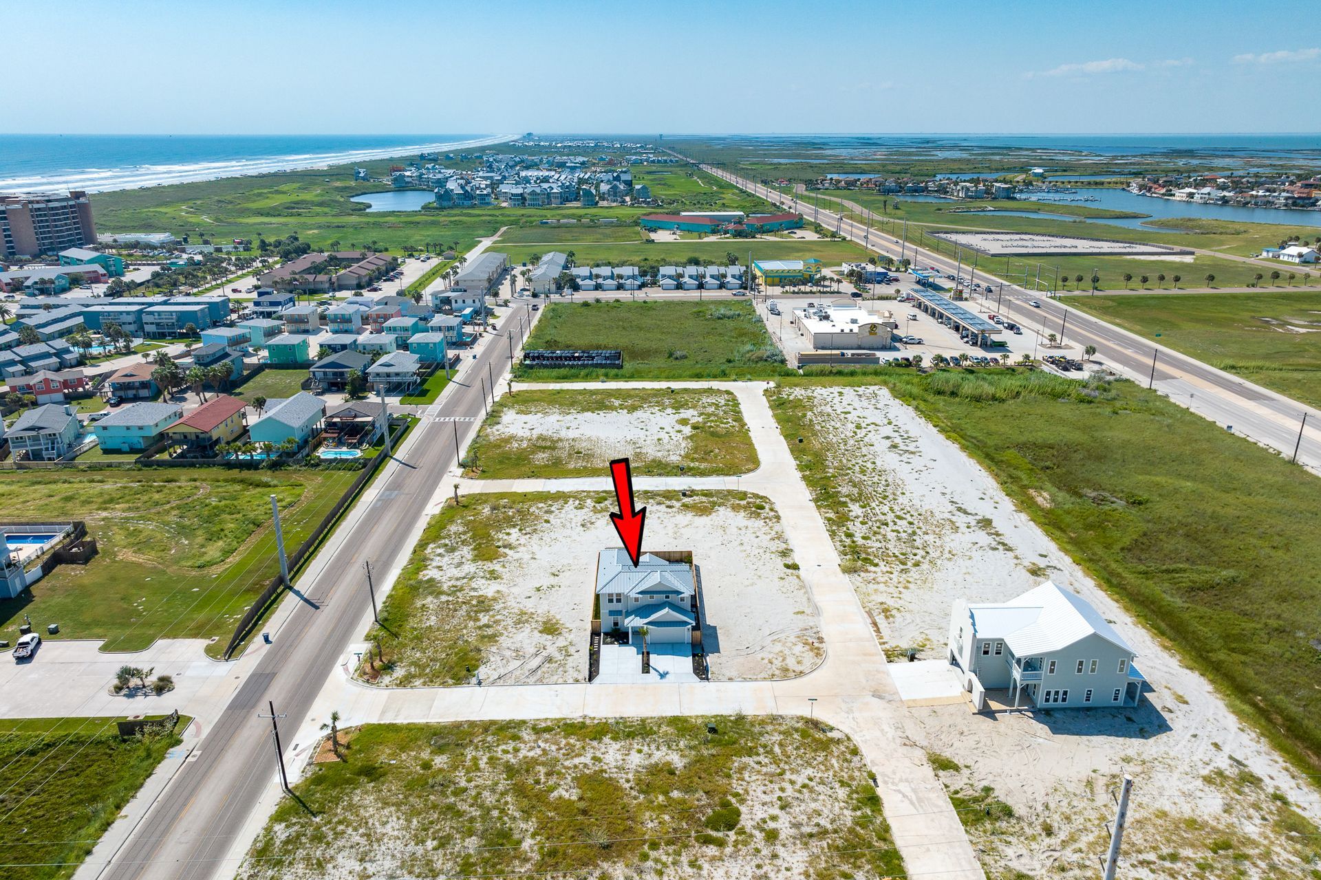 An aerial view of a house with a red arrow pointing to it