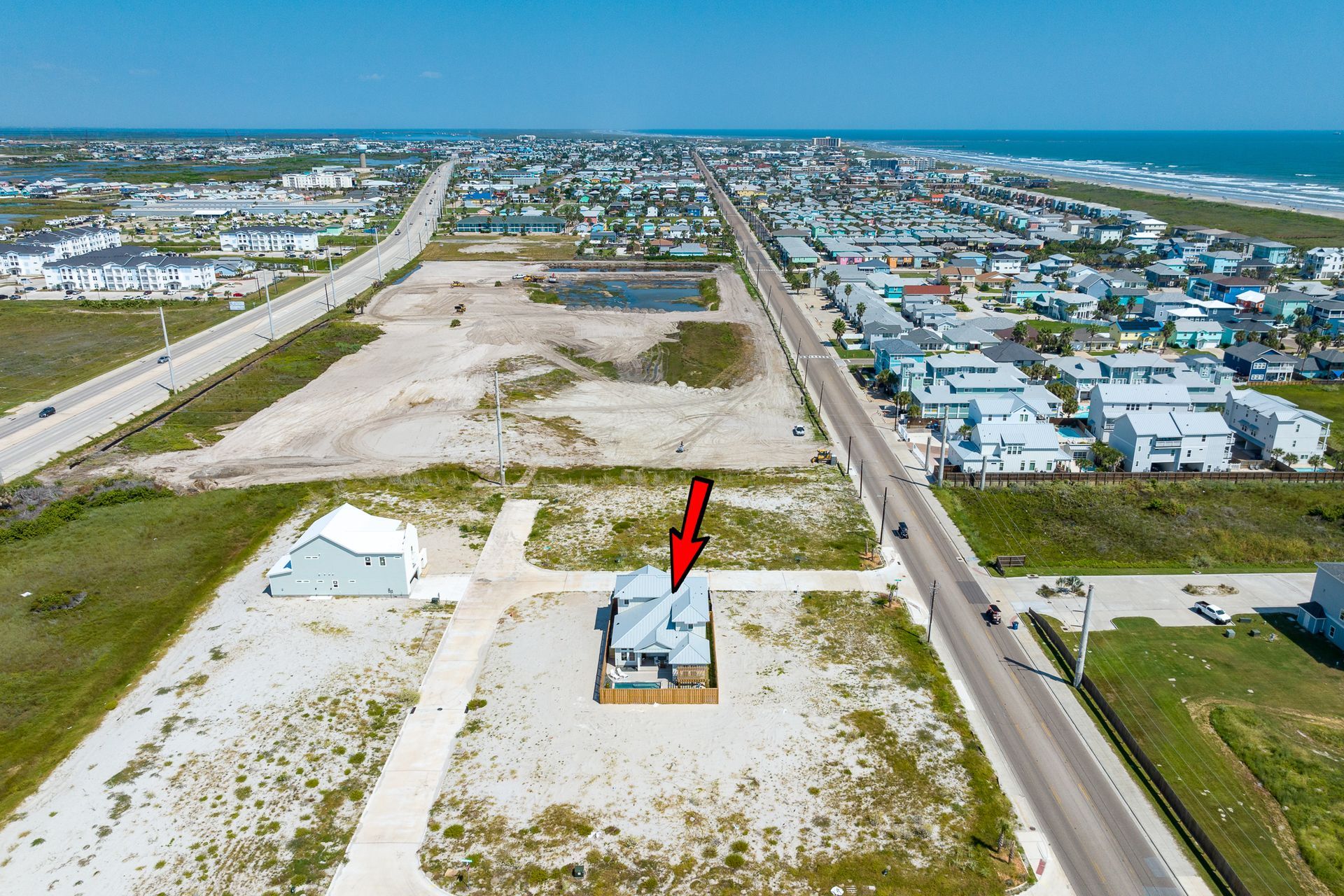 An aerial view of a house with a red arrow pointing to it.