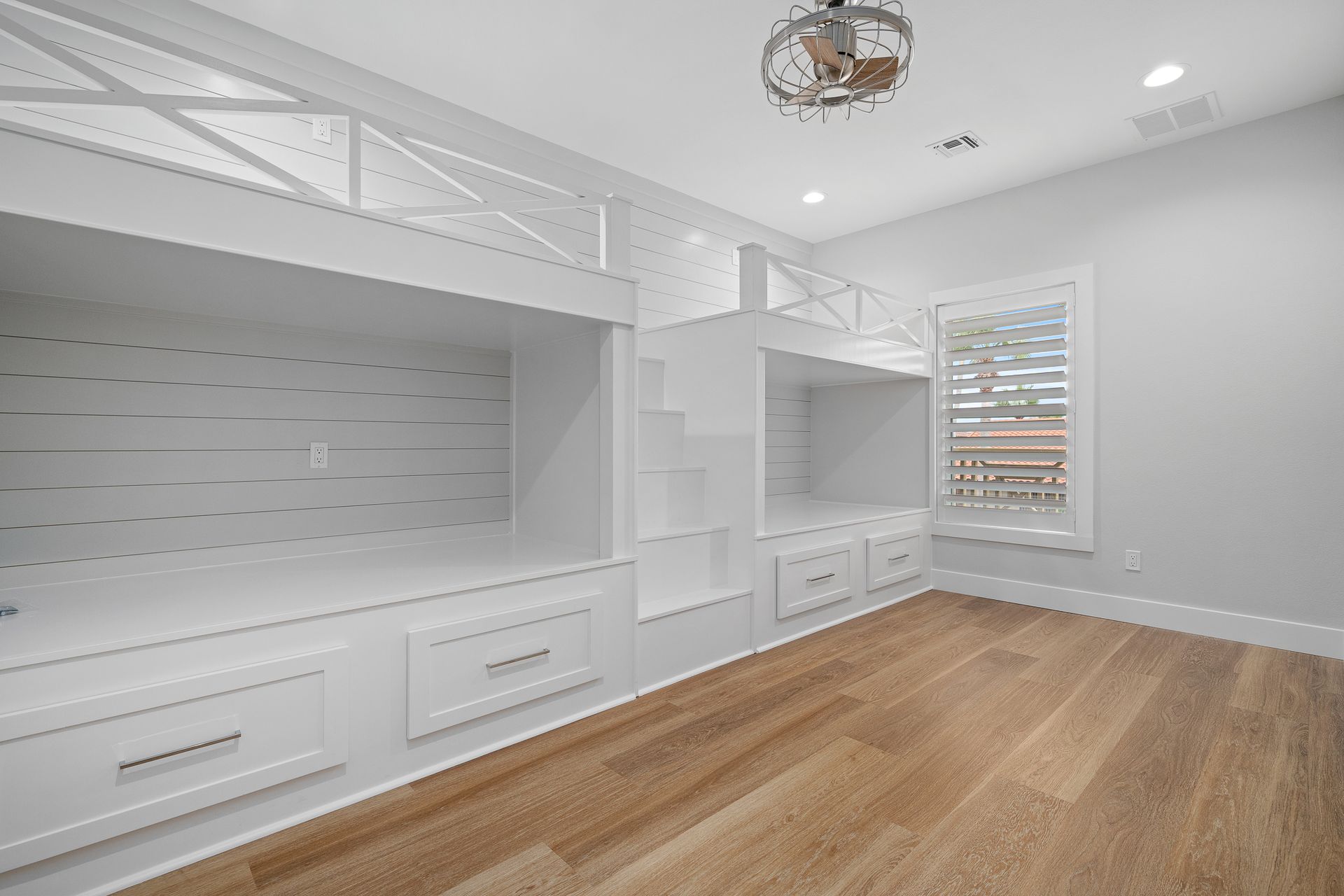 A bedroom with bunk beds and hardwood floors.