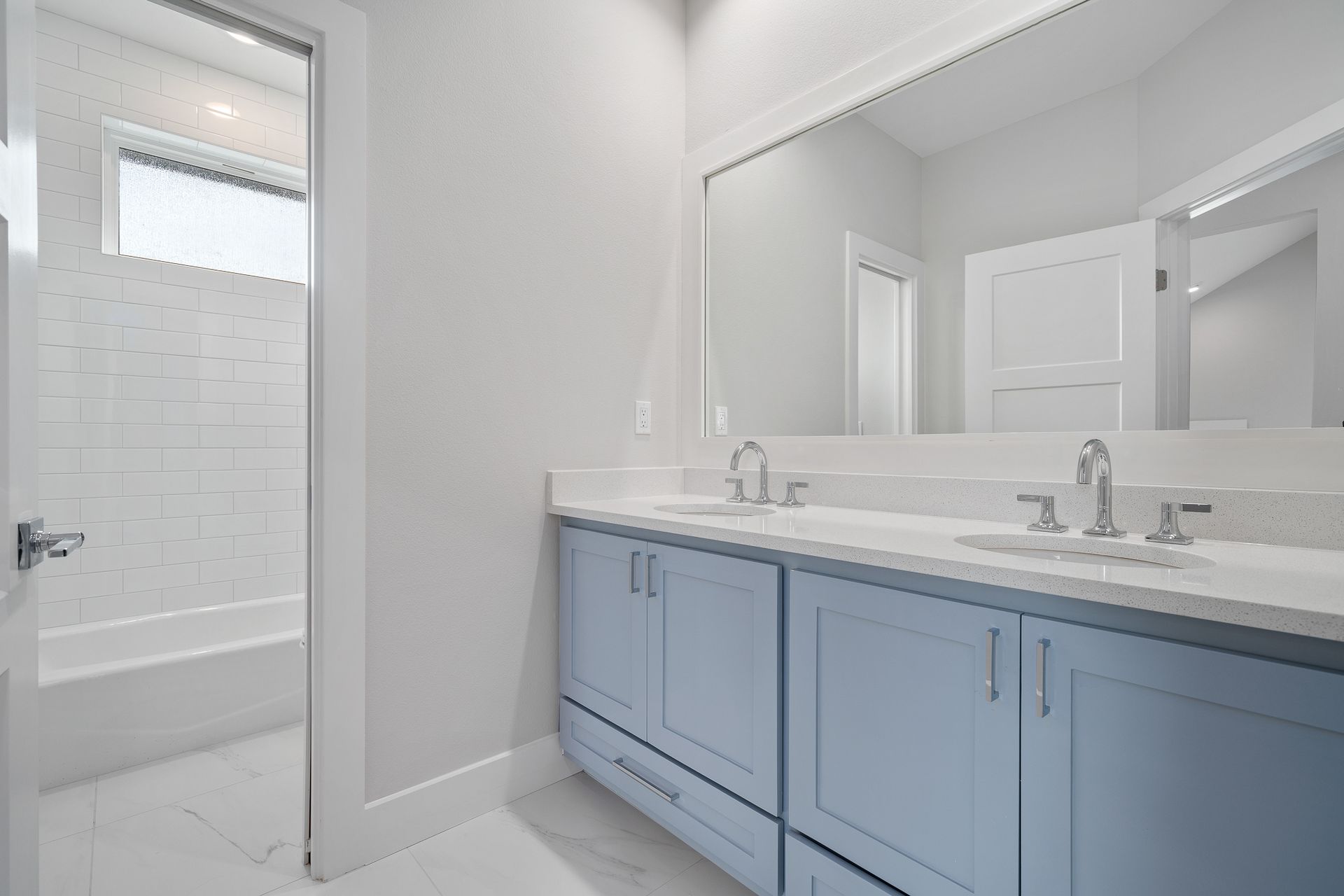 A bathroom with two sinks and a large mirror.