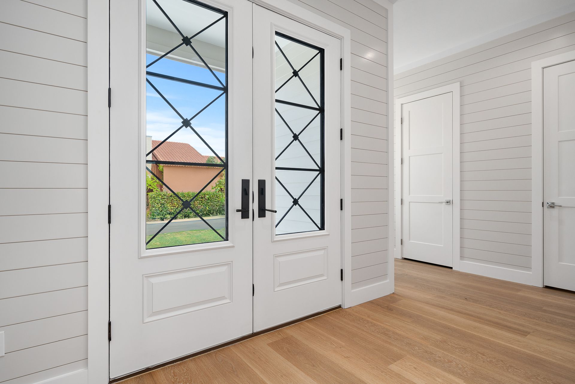 A hallway with a white door and a window