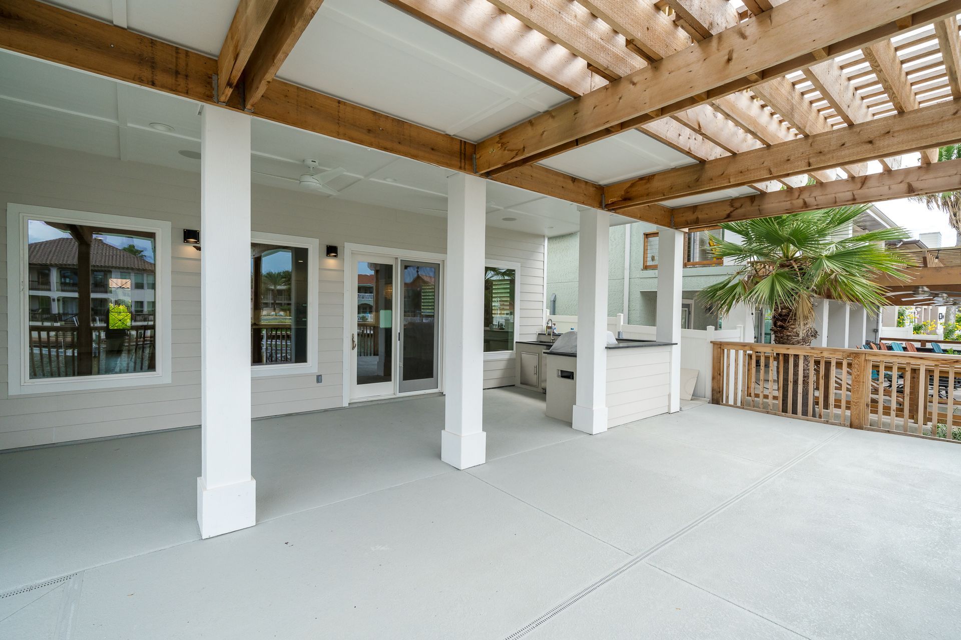A large patio with a pergola and sliding glass doors.