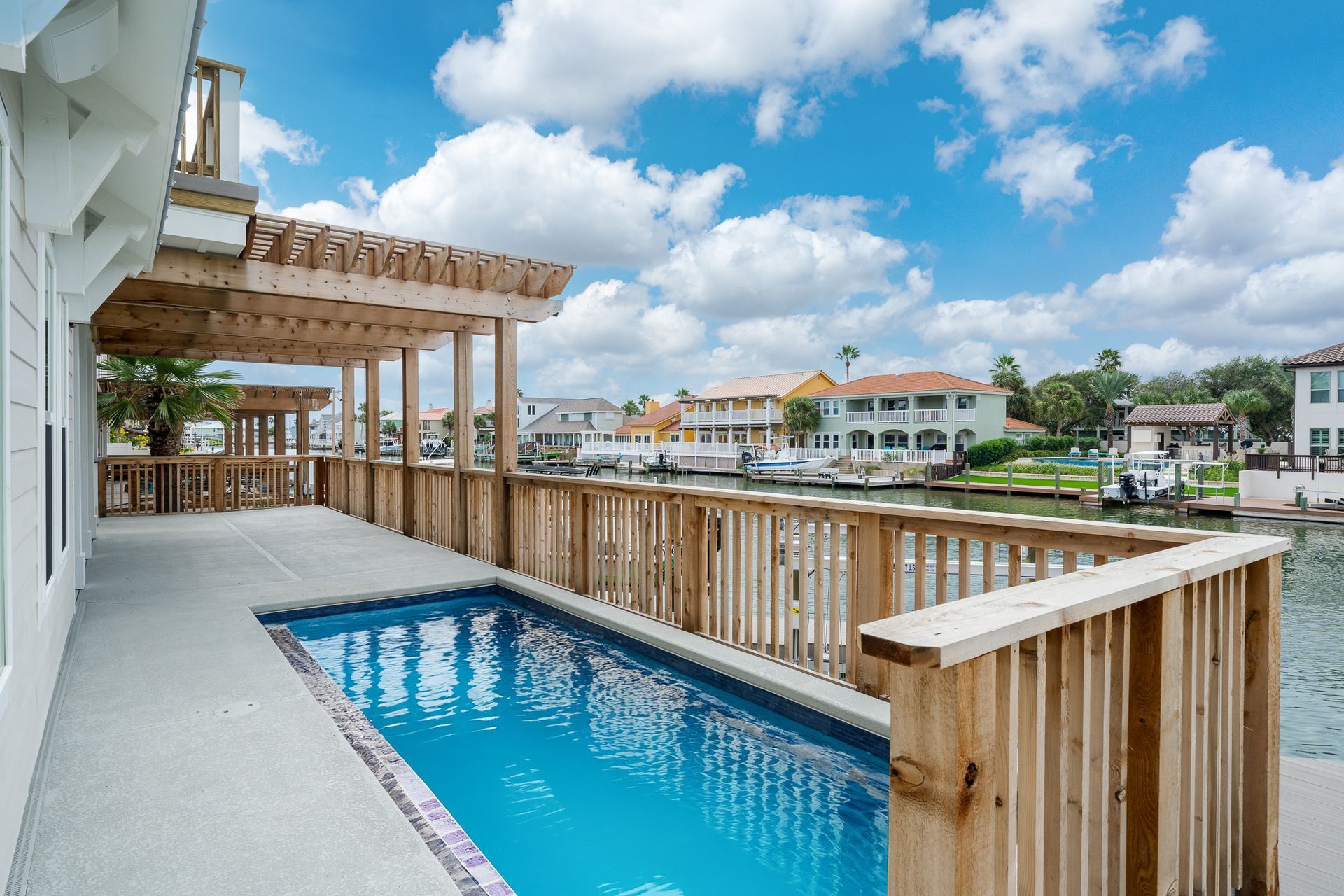 A large swimming pool is surrounded by a wooden deck.