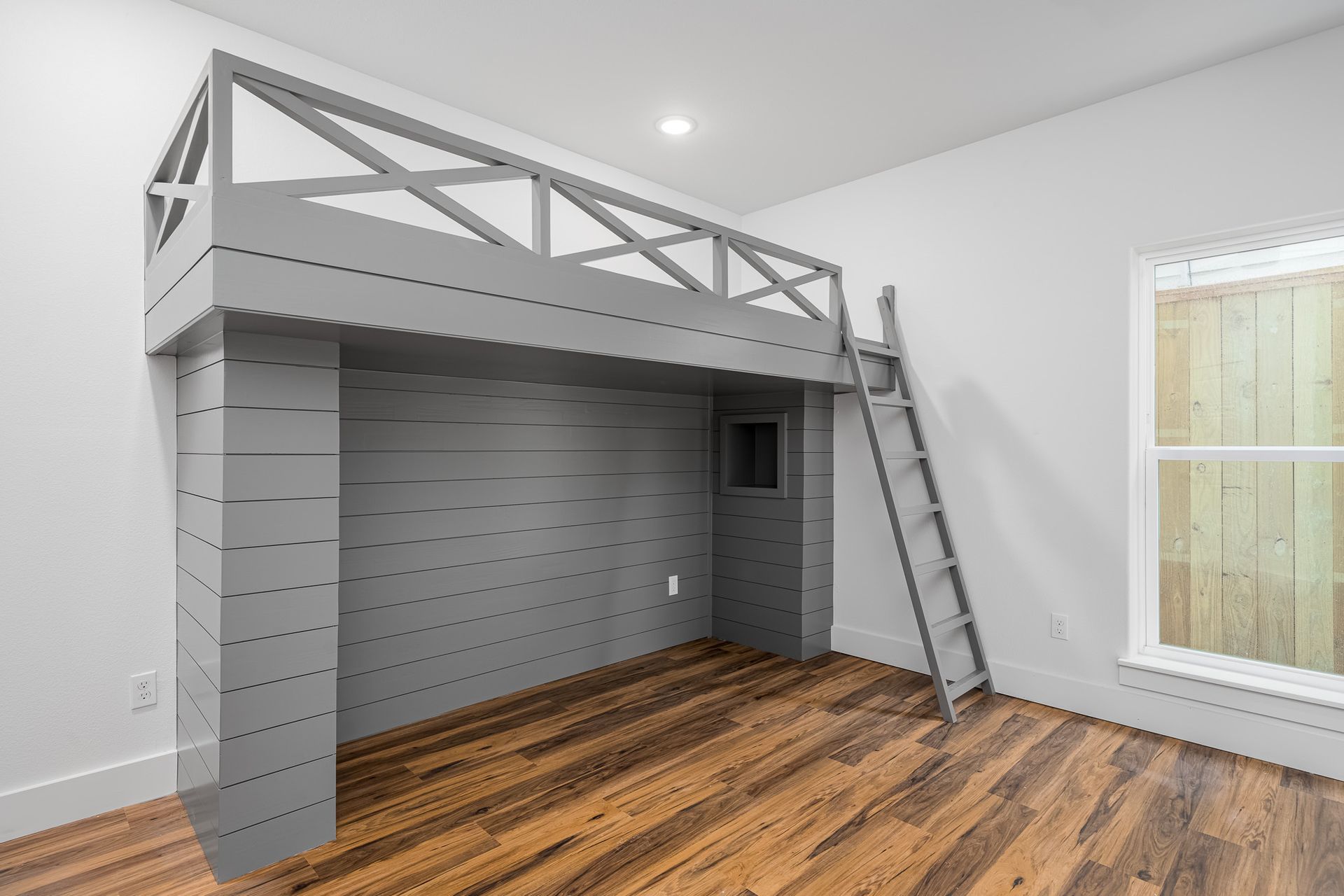 A bedroom with a bunk bed and a ladder.