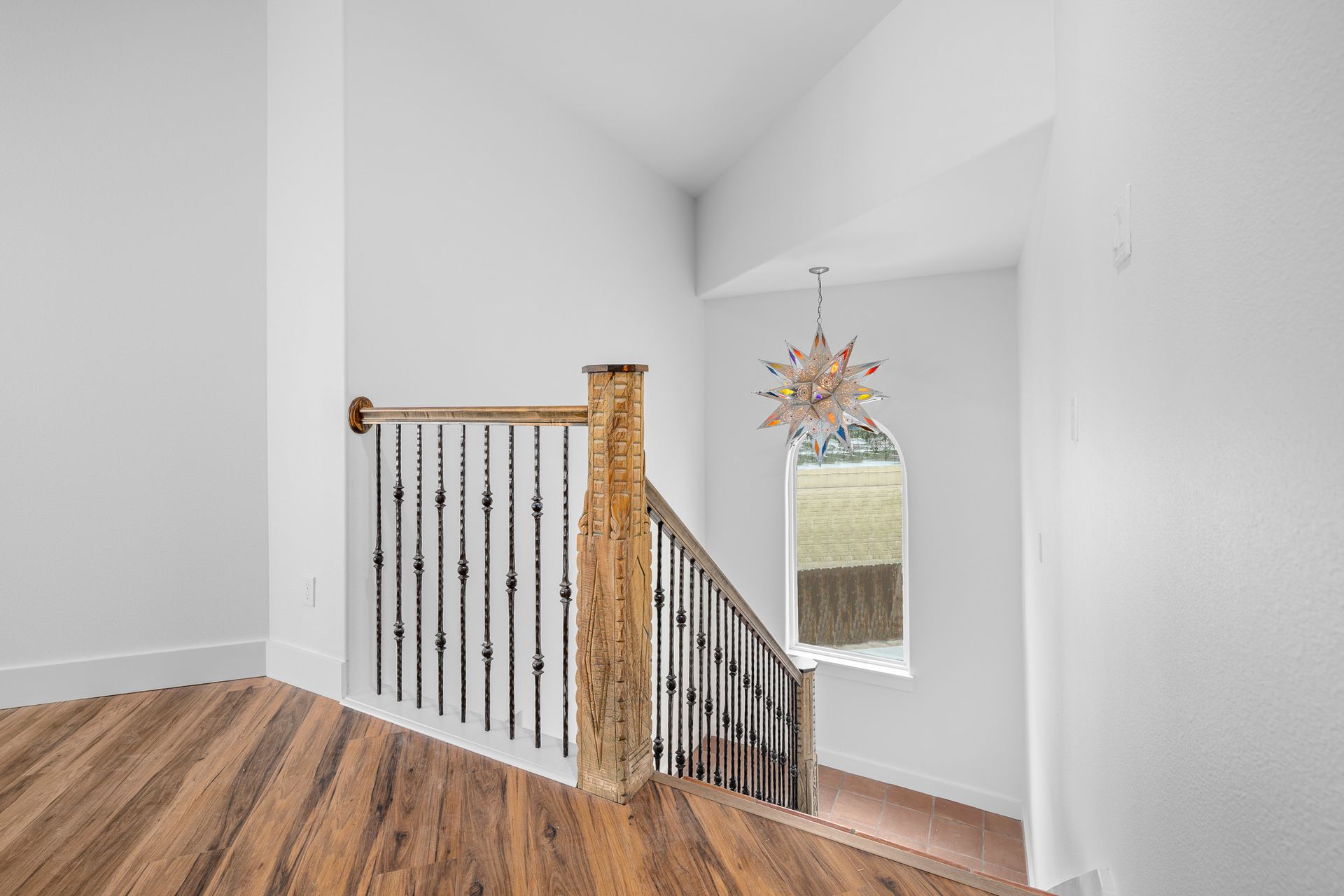 There is a staircase with a wooden railing and a mirror on the wall.