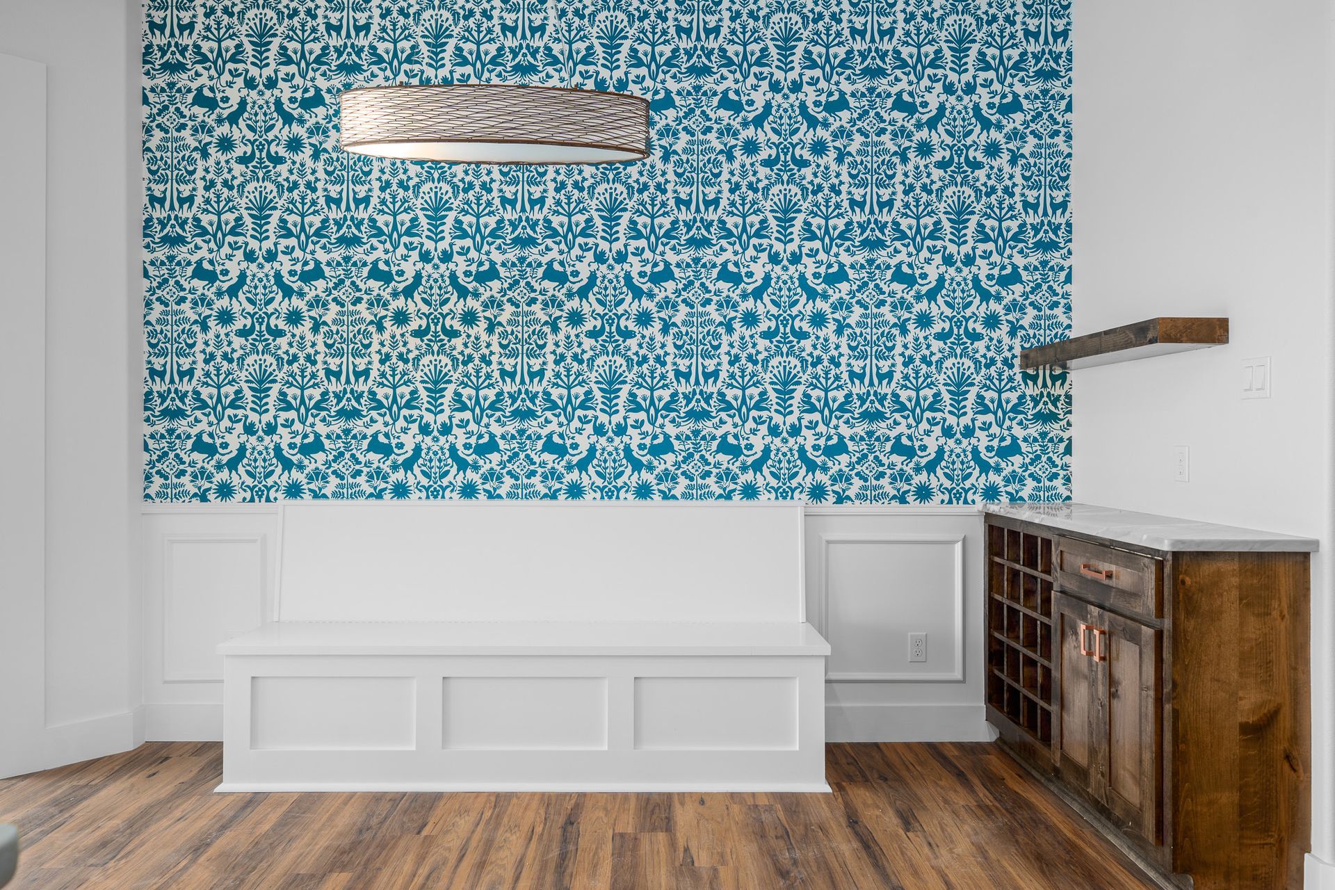 A room with a blue wall and a white bench.