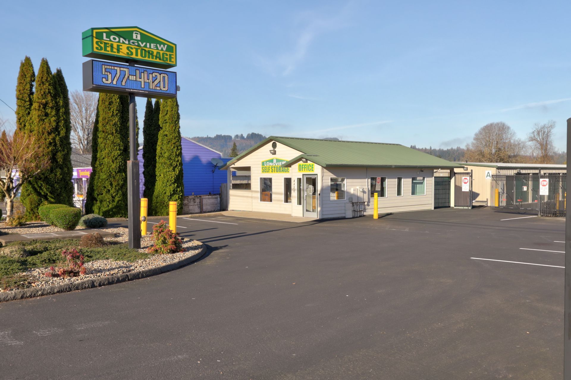 A building for a storage business, sign, asphalt parking lot.