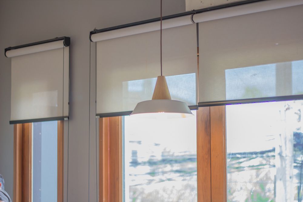 There Are Two Windows With Blinds and a Lamp Hanging From the Ceiling — Artizen Curtains in Coolum, QLD