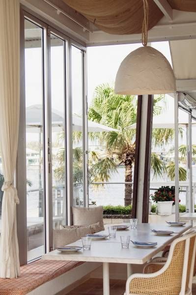 A Dining Room With a Table and Chairs and a Large Window — Artizen Curtains in Mooloolaba, QLD