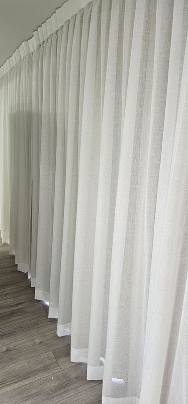 A Row of White Curtains Hanging on a Wall in a Room — Artizen Curtains in Mooloolaba, QLD