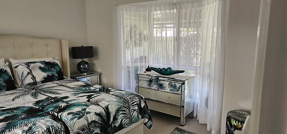 A Bedroom With a Bed, Dresser, Nightstand and Window — Artizen Curtains in Mooloolaba, QLD