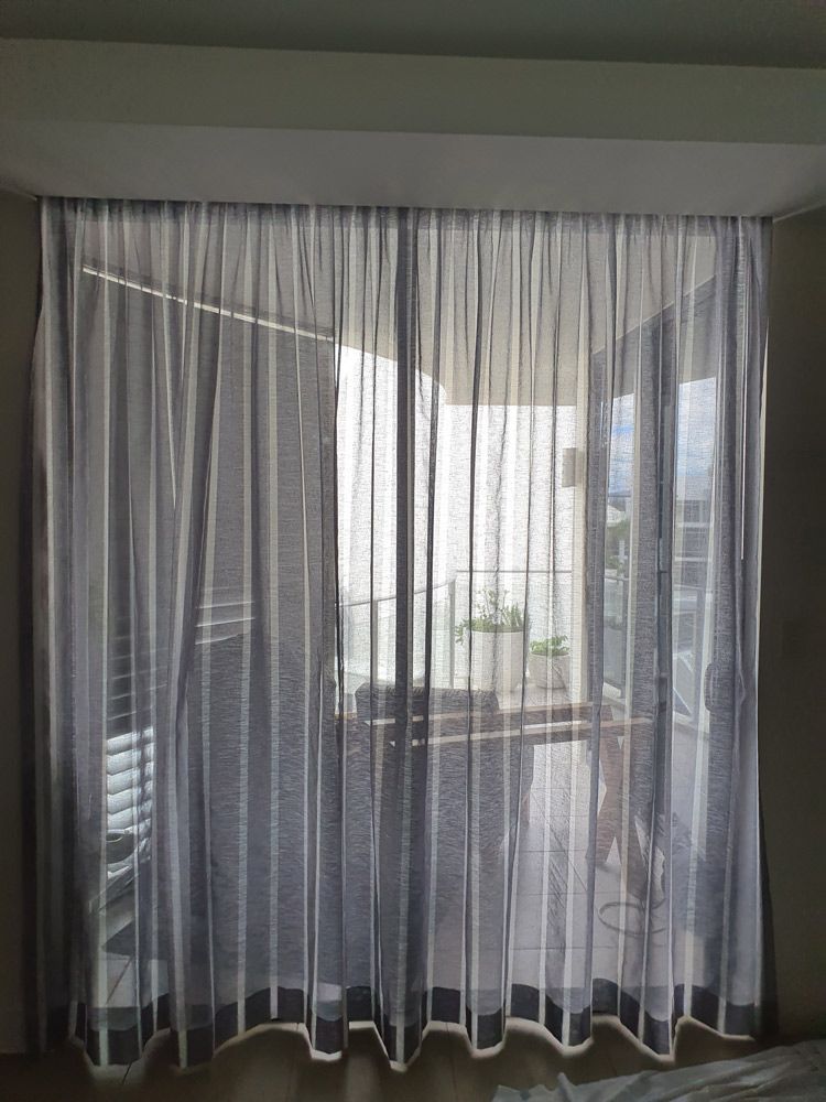 A Bedroom With a Sliding Glass Door and Sheer Curtains — Artizen Curtains in Mooloolaba, QLD