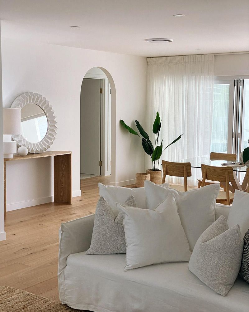 A Living Room With a White Couch and a Mirror — Artizen Curtains in Mooloolaba, QLD