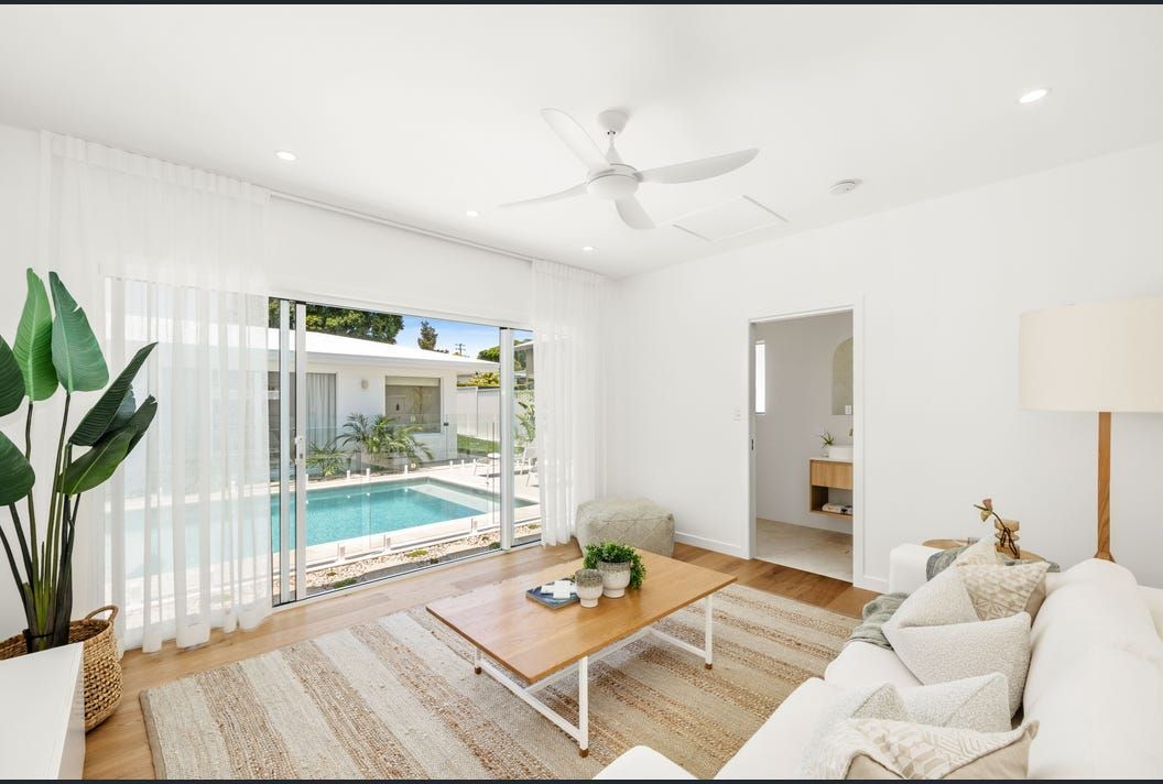 A Living Room With a Sliding Glass Door Leading to a Swimming Pool — Artizen Curtains in Mooloolaba, QLD
