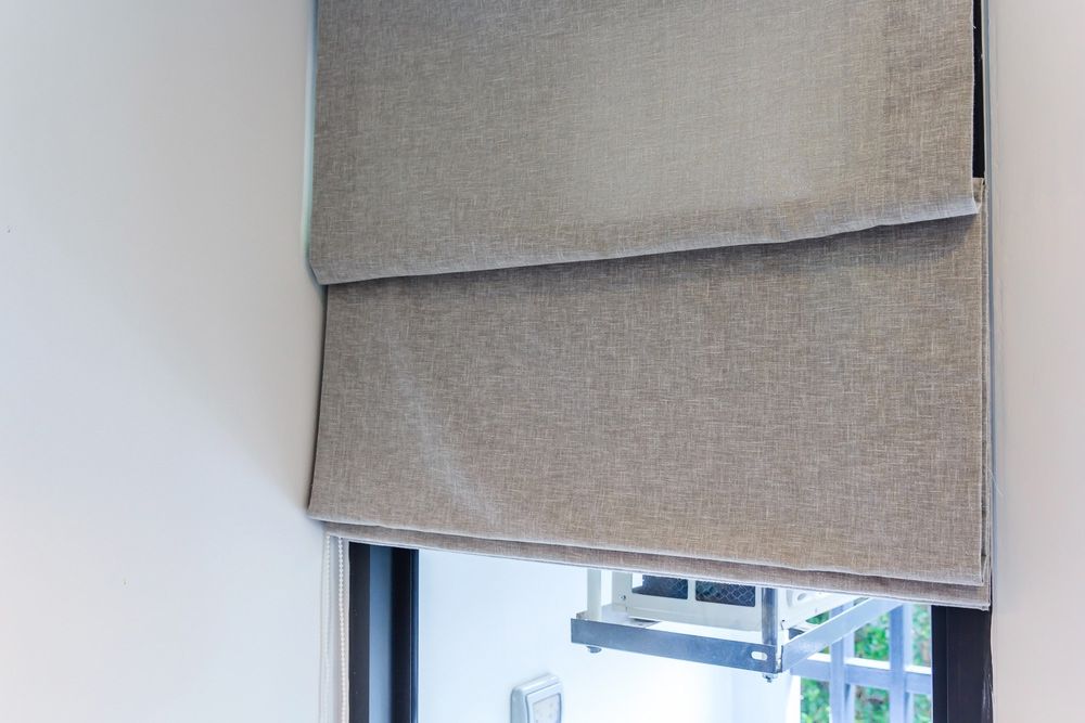 A Close up Of a Window with A Roman Blind on It — Artizen Curtains in Mooloolaba, QLD