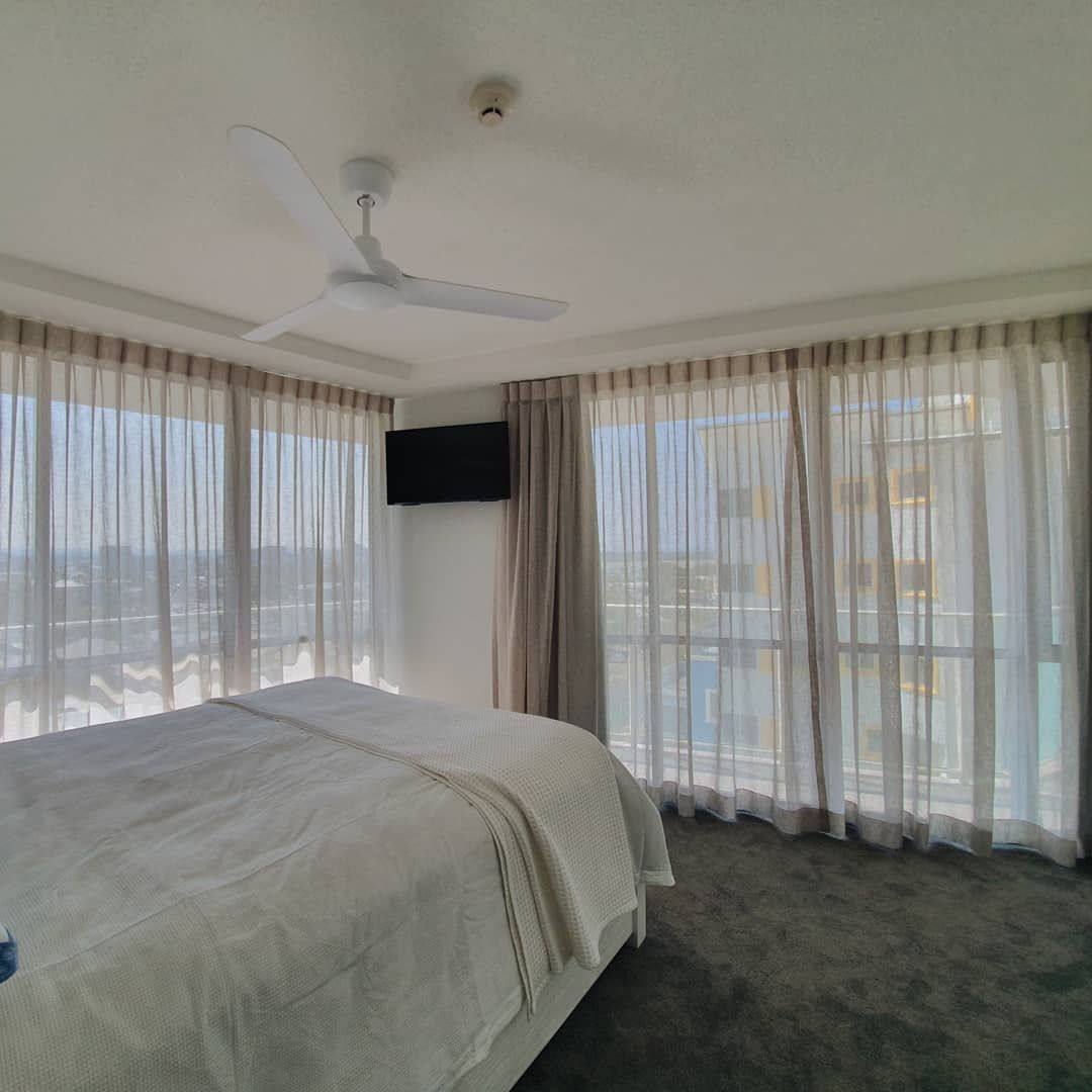 A Bedroom with A Large Bed and A Ceiling Fan — Artizen Curtains in Palmwoods, QLD